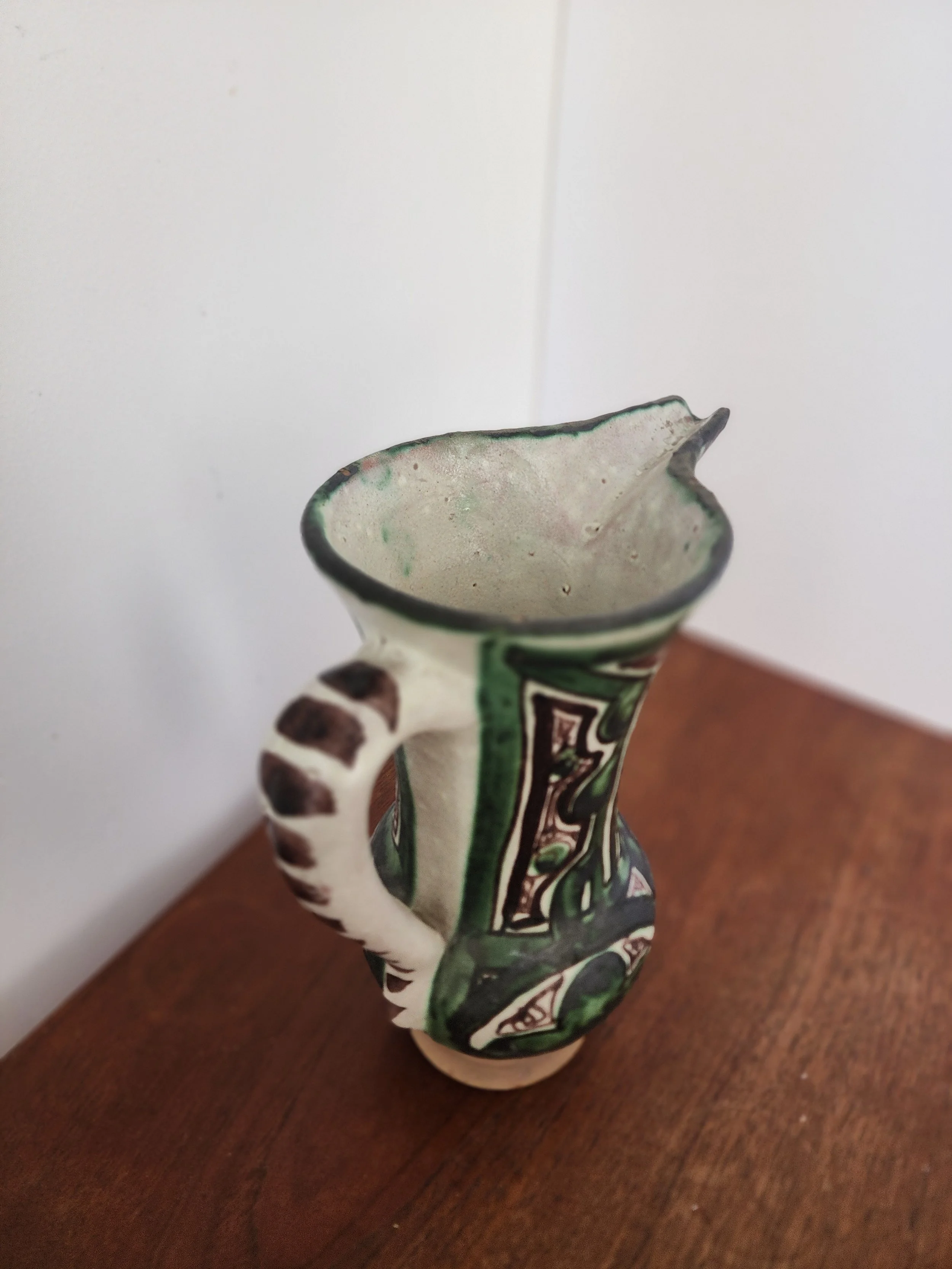 “Side view showing sculptural handle and spout of vintage Punter ceramic pitcher.”