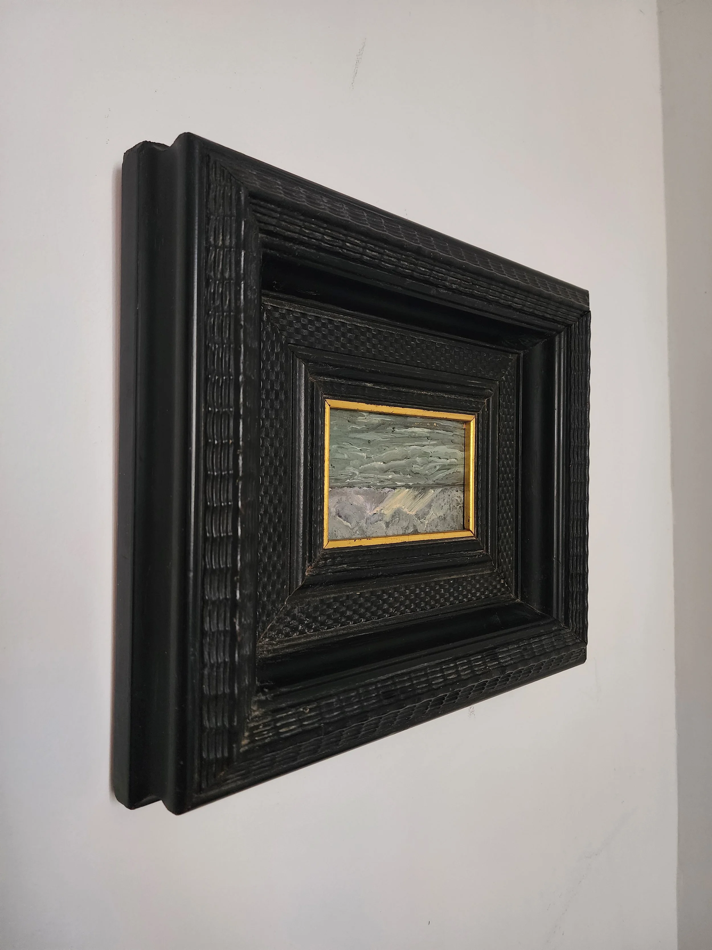 Vintage miniature seascape oil painting in black ripple frame.