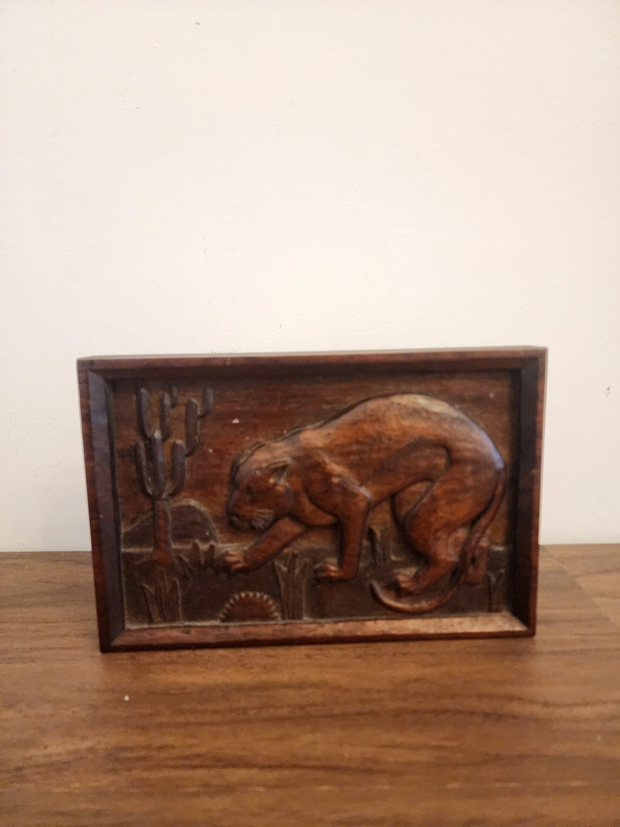 Wooden wall art depicting panther and cactus motif.