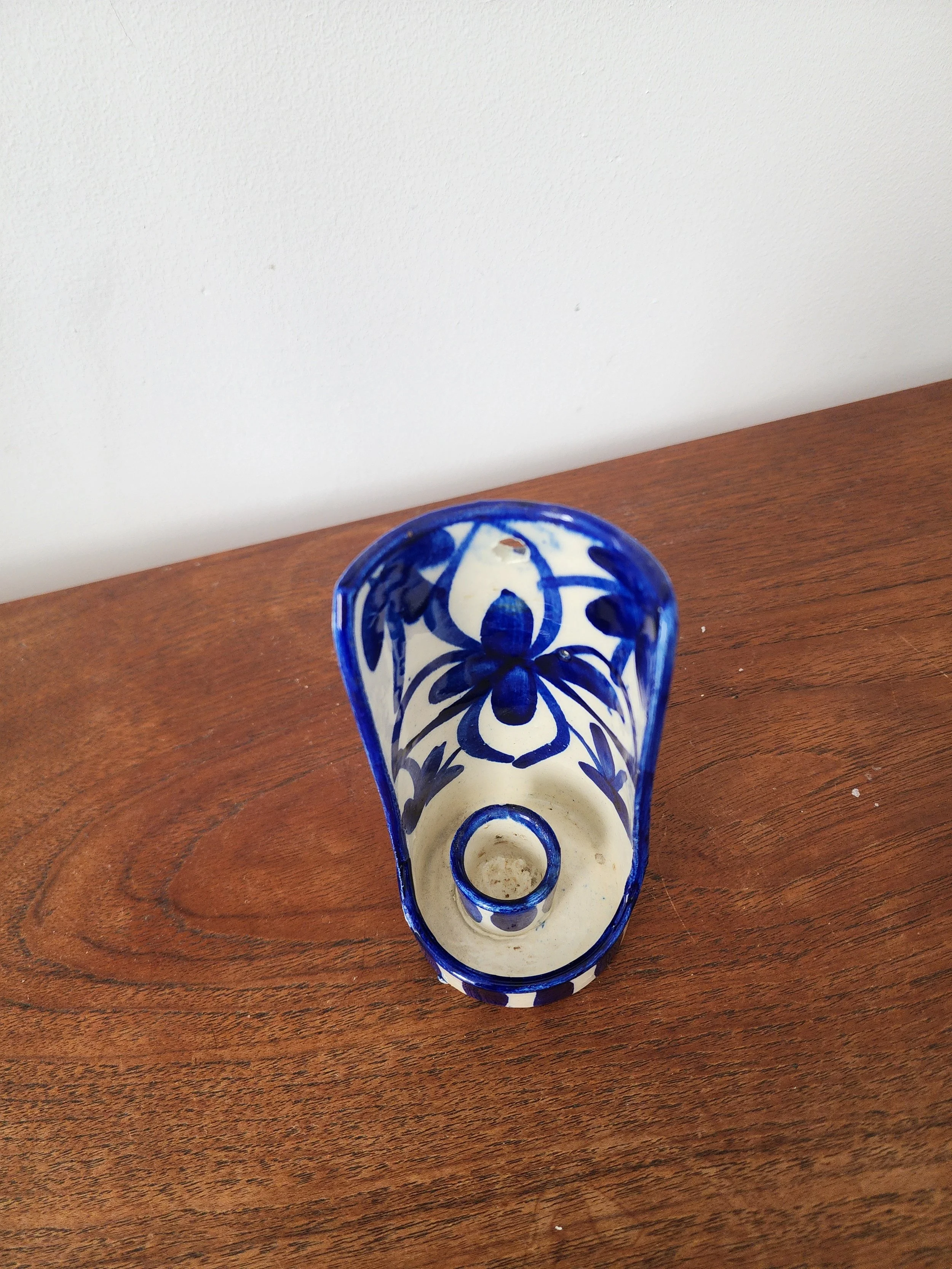 White pottery candlestick with cobalt blue stripes and flowers.