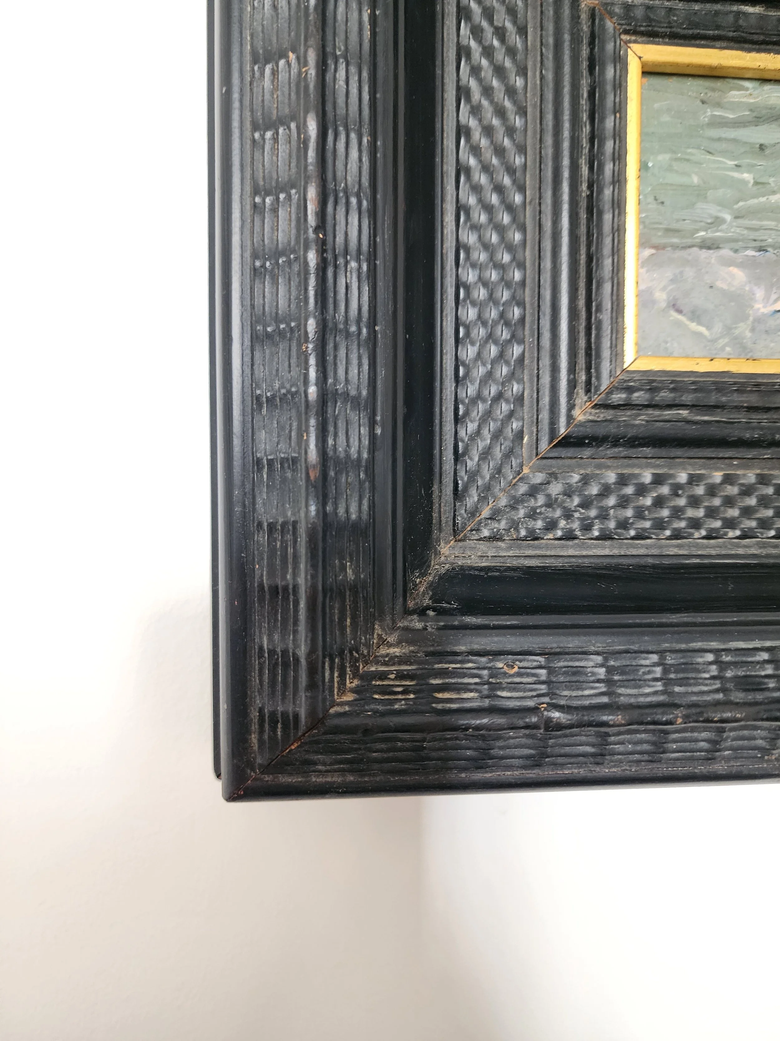 Small coastal painting with gold-trimmed black frame.