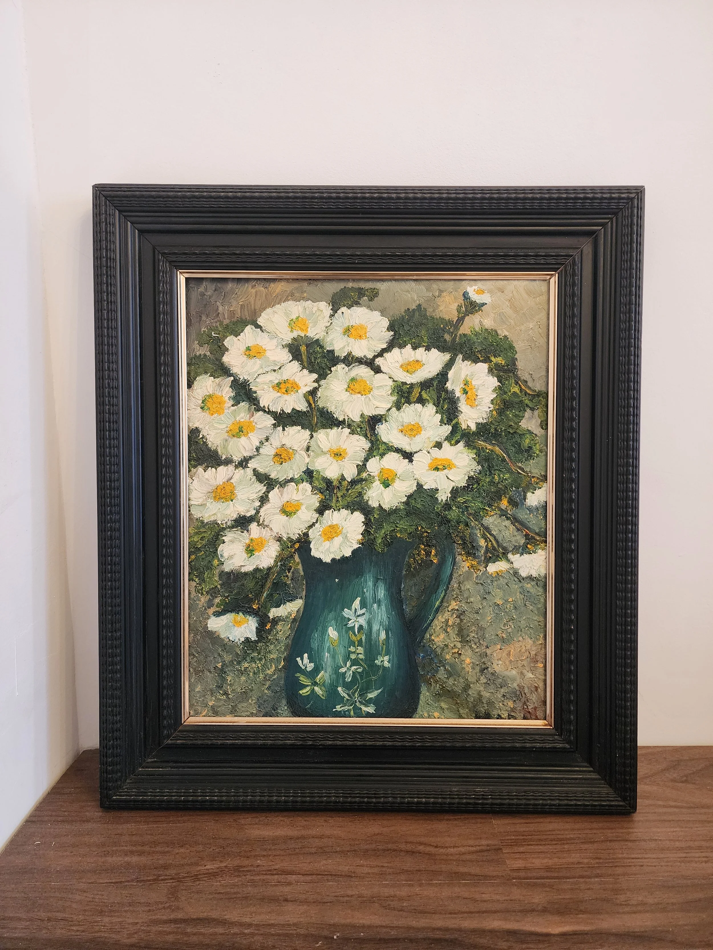 Vintage textured oil painting of daisies in a teal vase with black wooden frame