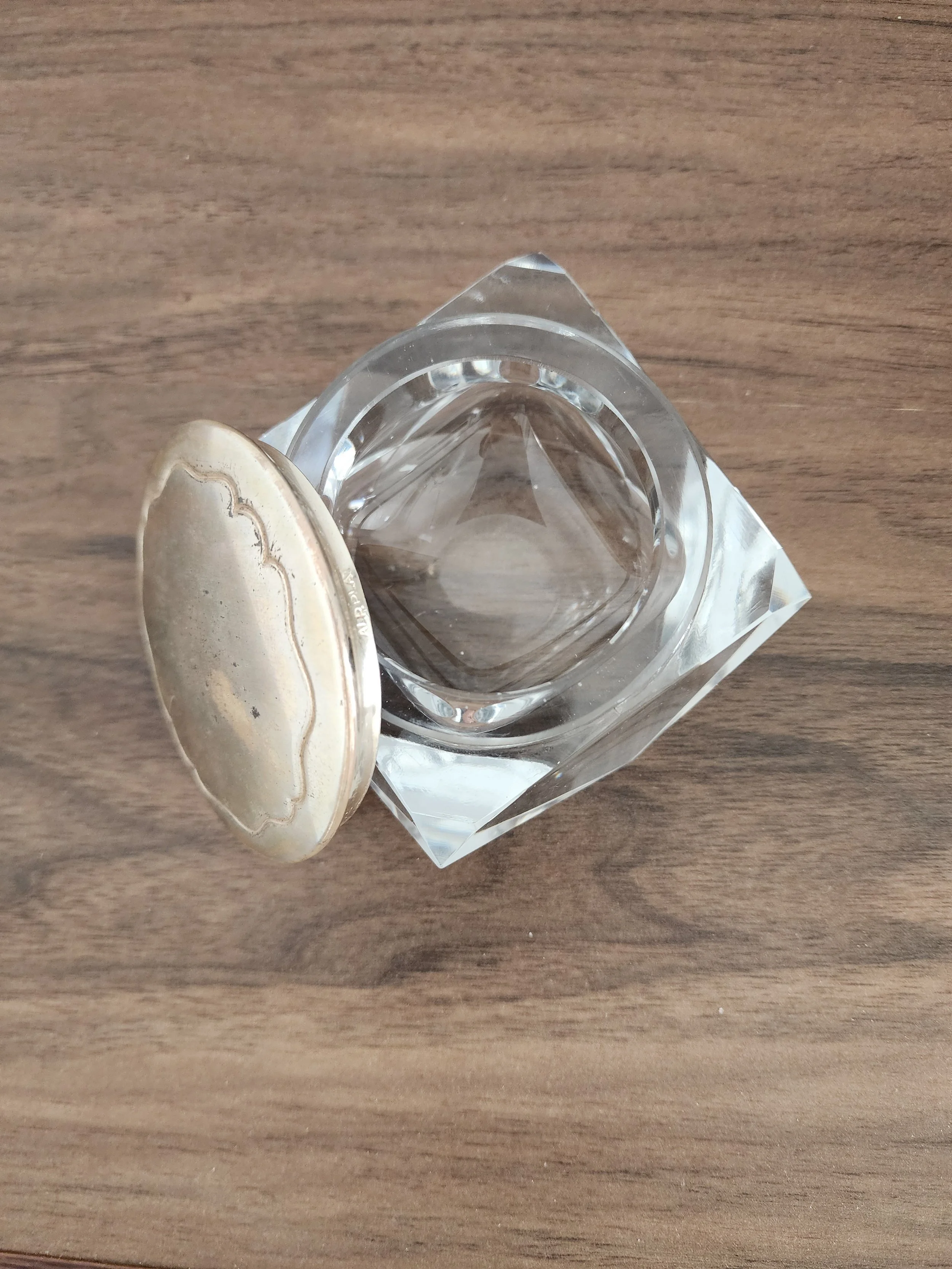 Jar styled on a mirrored tray with jewelry for scale.