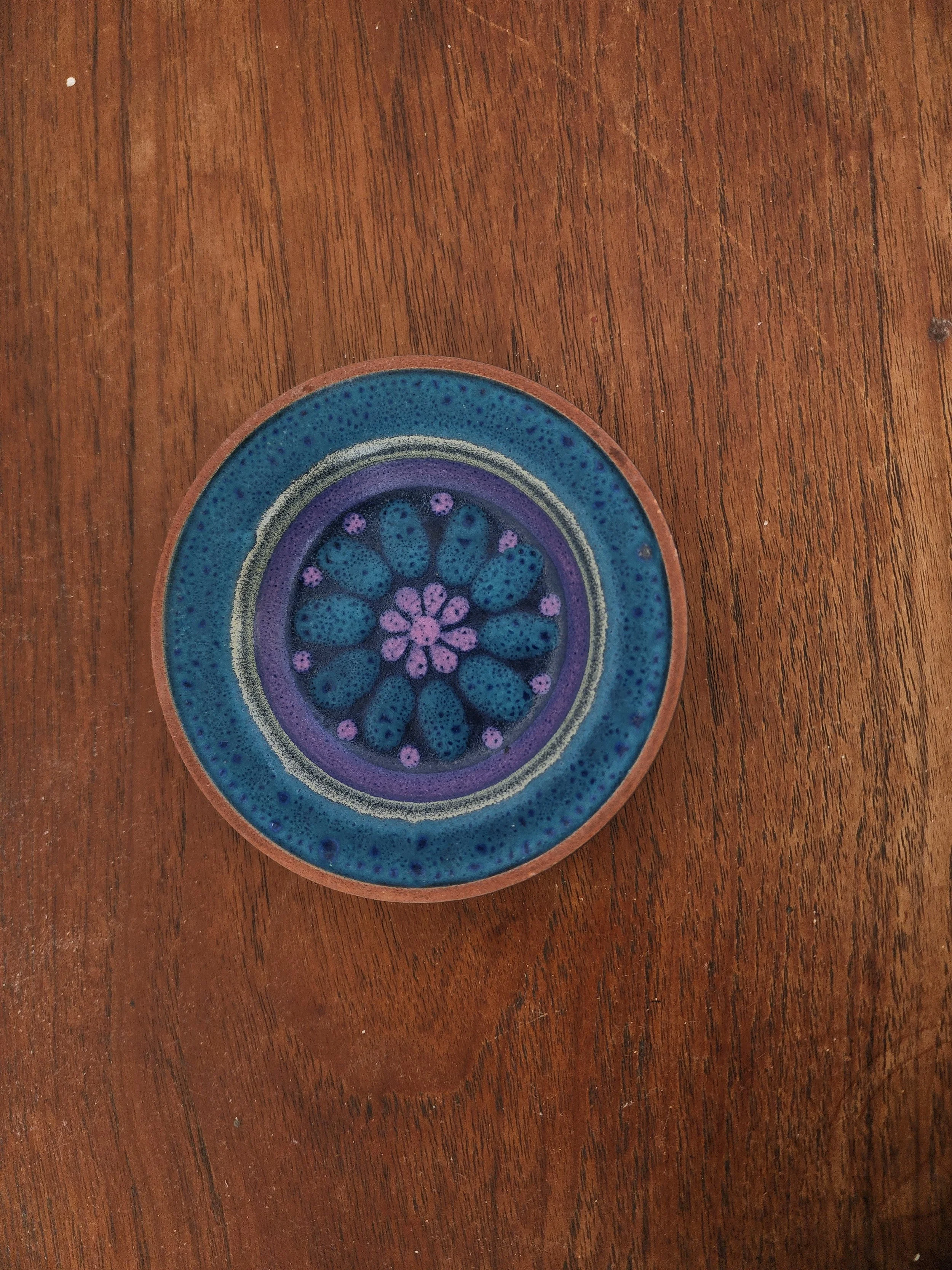 1970s blue glazed ceramic bowl on wooden surface.