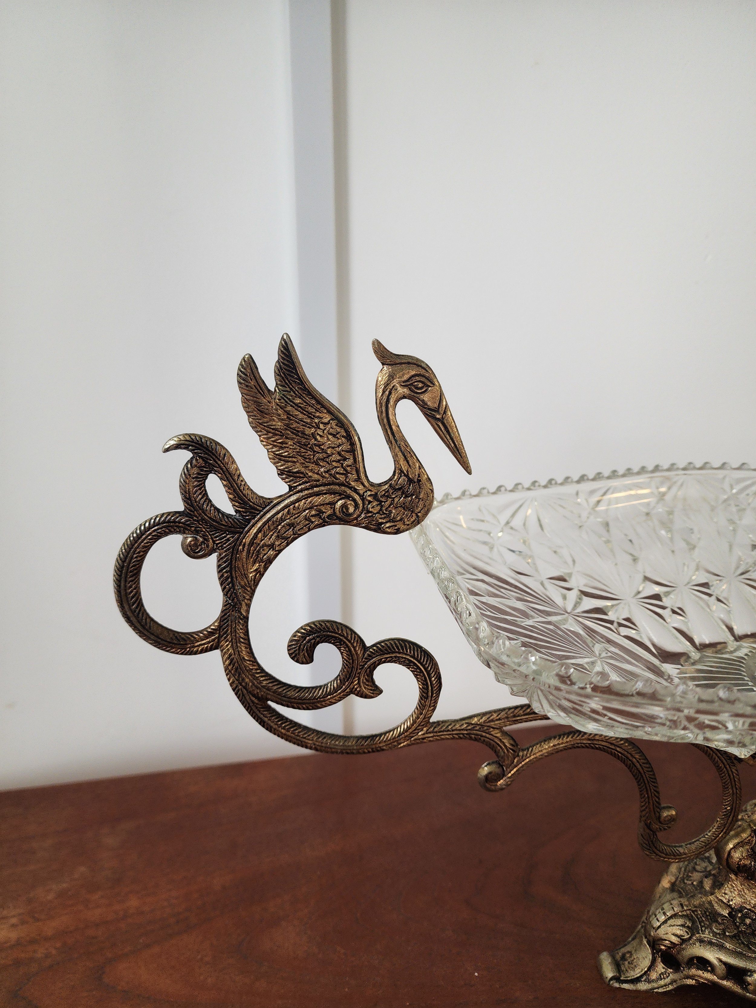 “Vintage baroque-style brass and glass fruit bowl with sculptural swan details.”
