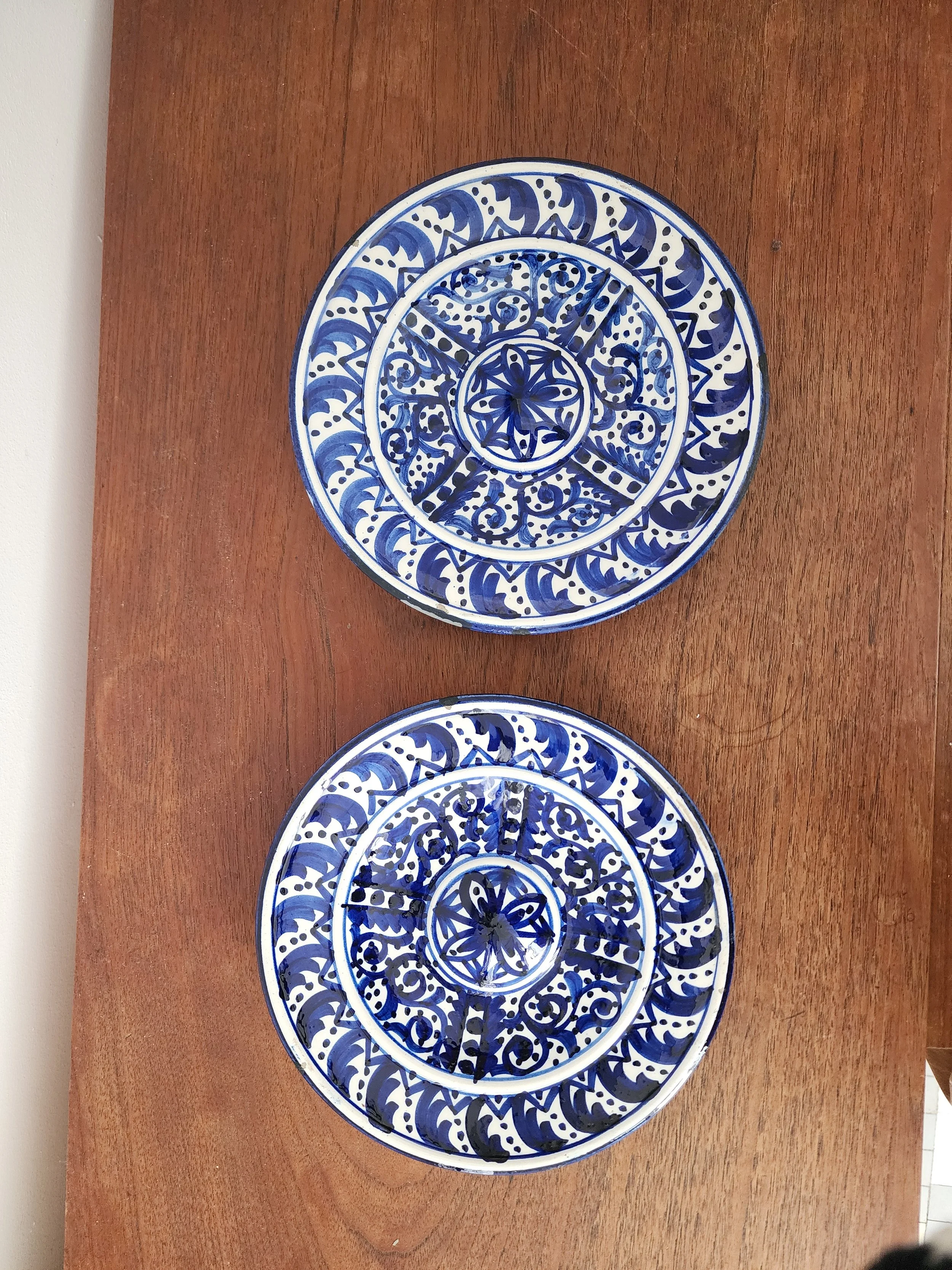 Wall-mounted blue and white vintage plates on neutral background.