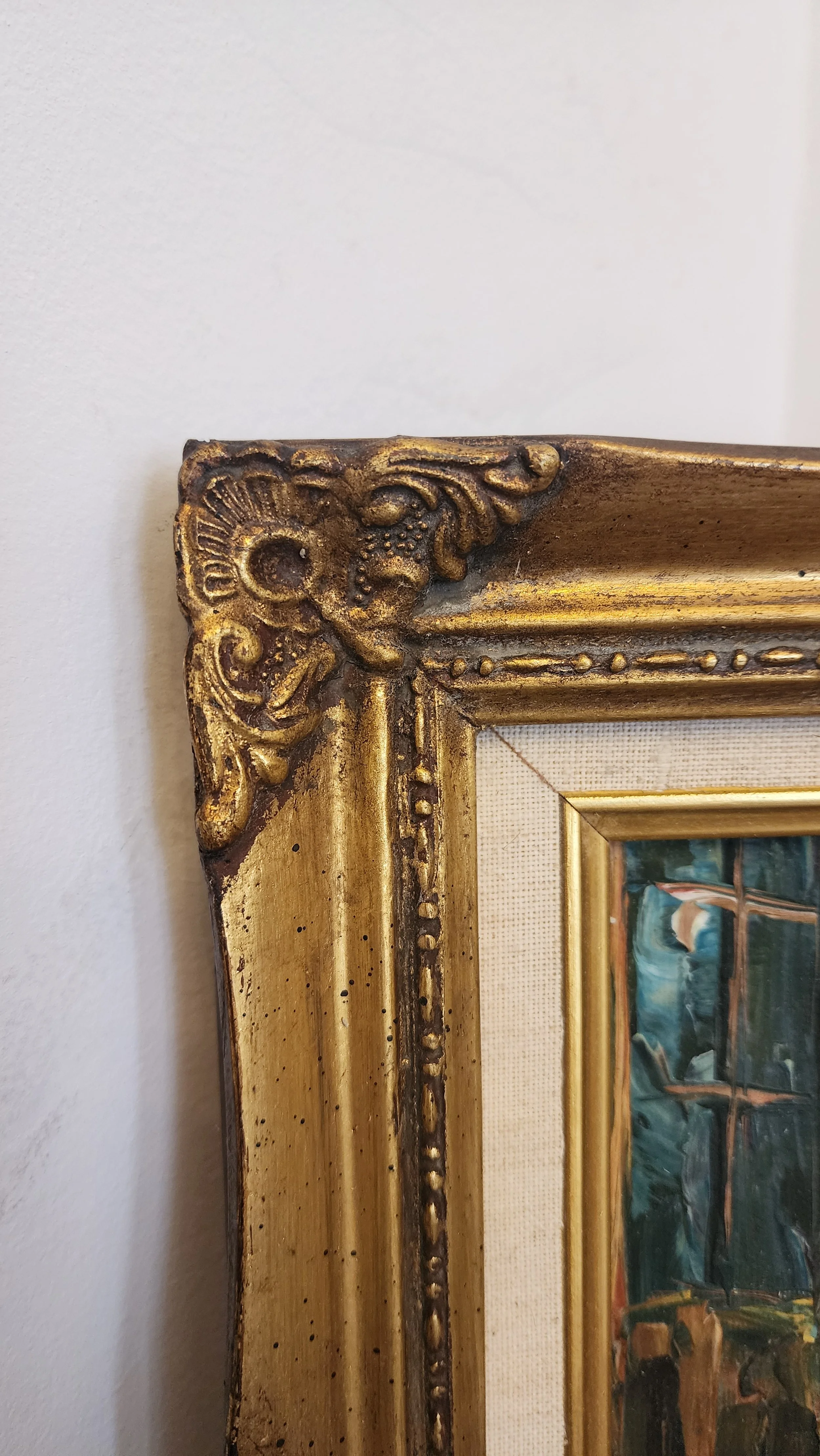 Detail of carved gold frame corner showing light wear.