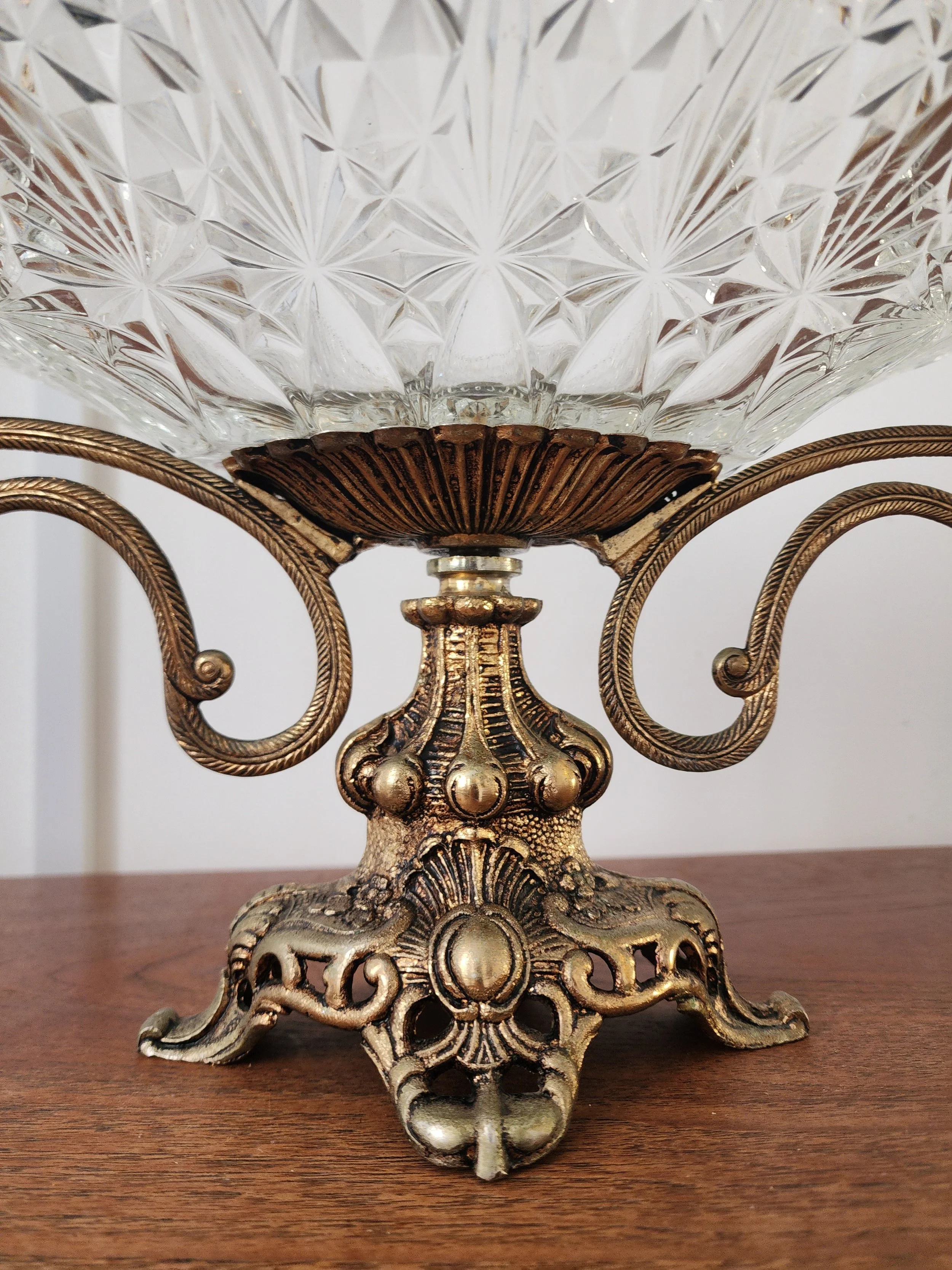 “Ornate antique serving bowl with decorative brass base and clear cut-glass dish.”
