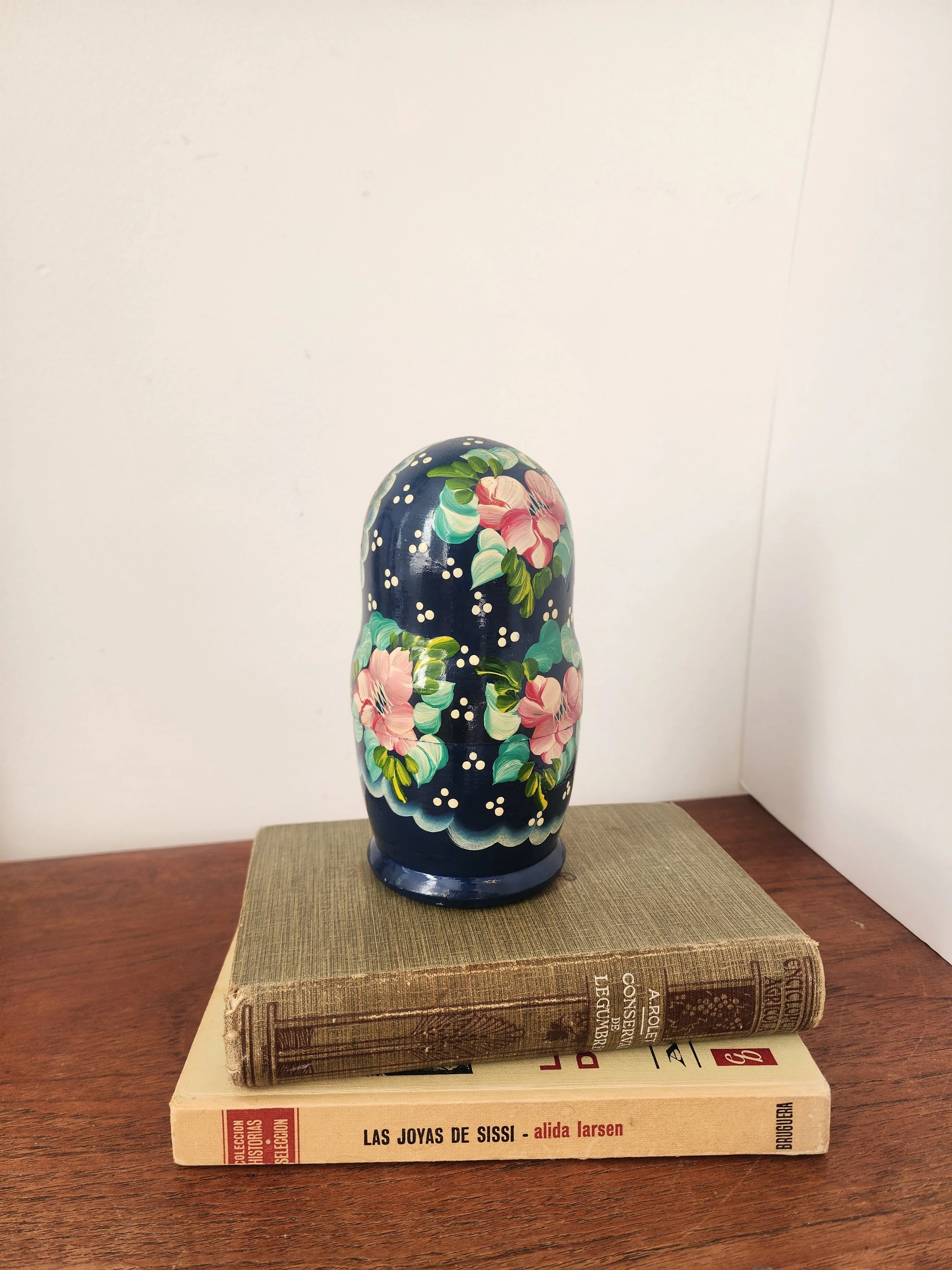 “Five-piece wooden Russian matryoshka set with traditional faces and floral patterns.”