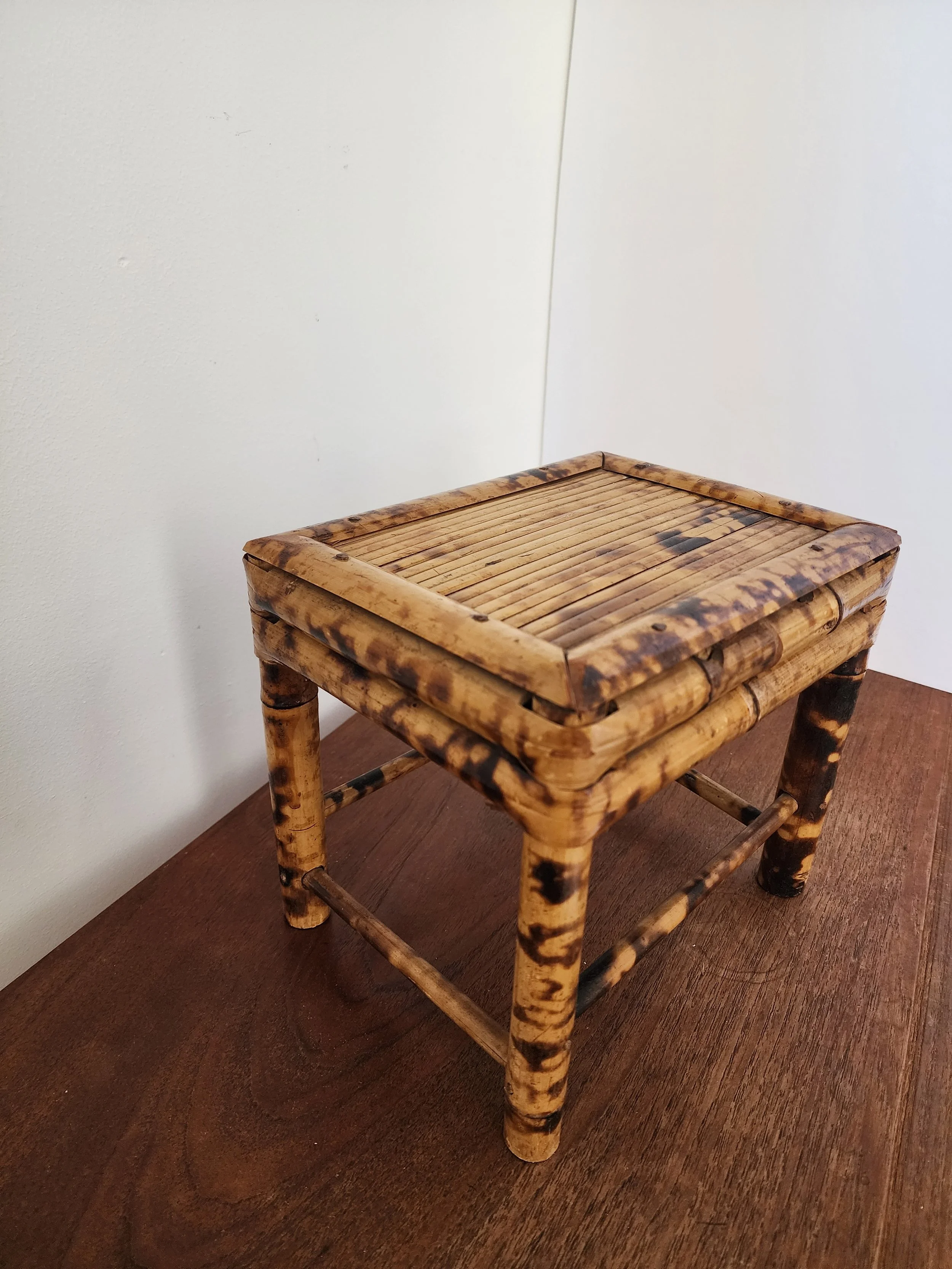 Handcrafted bamboo stool showing unique scorched details.