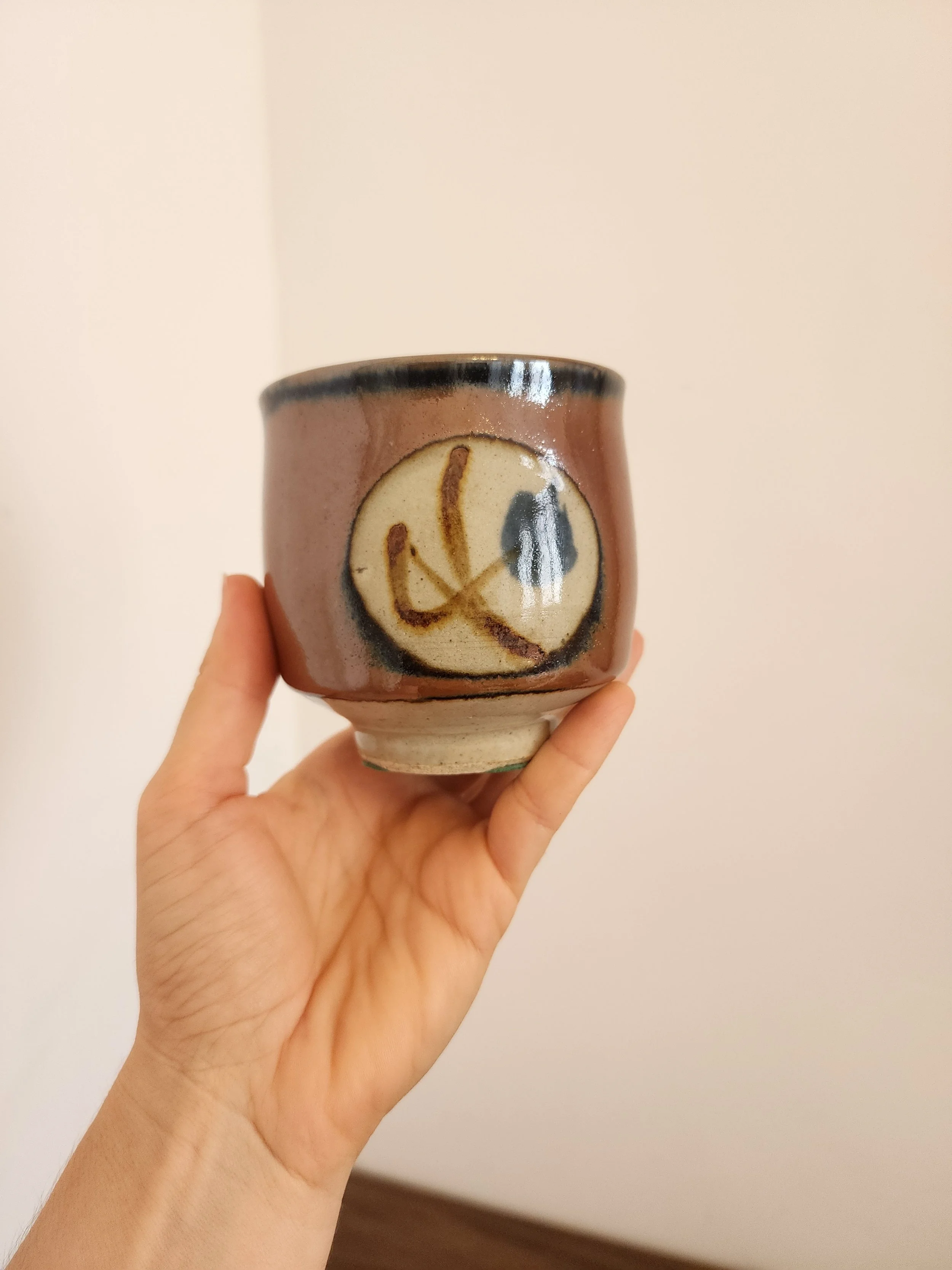 Side view showing cream medallion and abstract blue-brown motif.