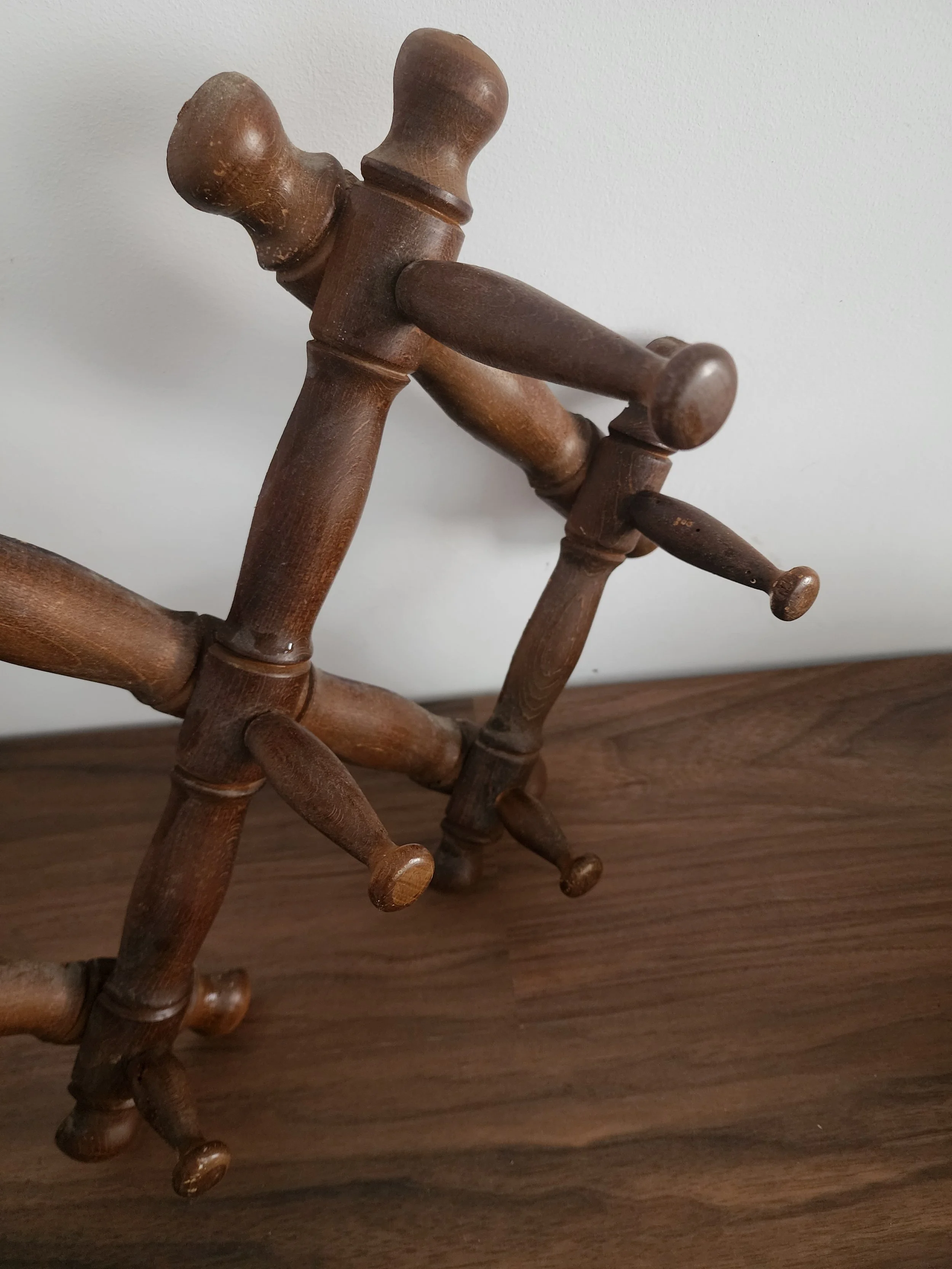 Foldable peg rack made of warm brown wood.