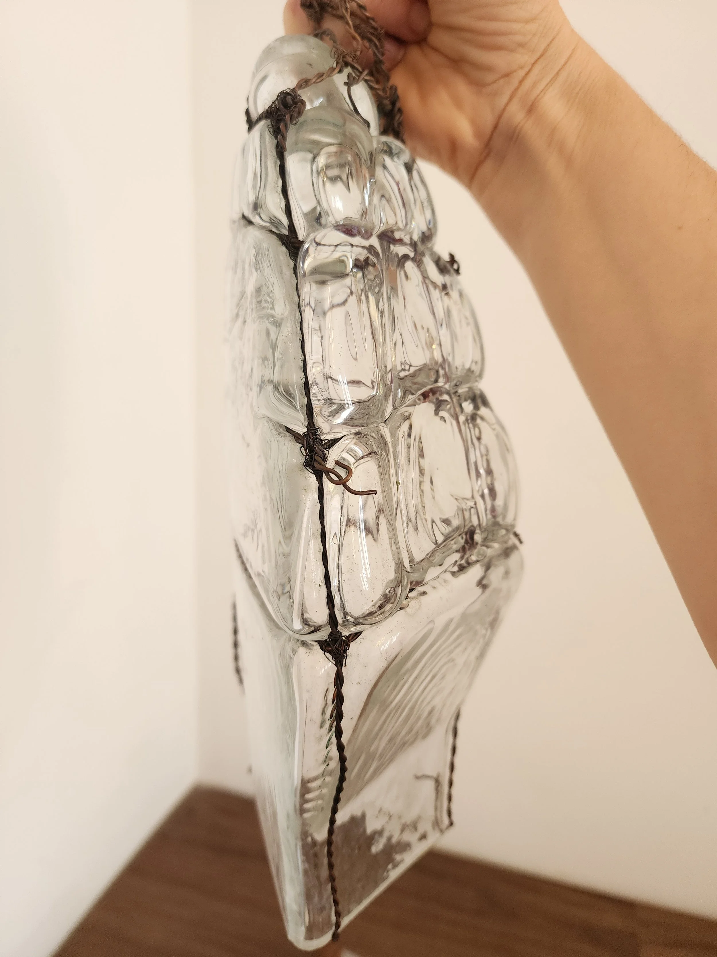 “Handmade vintage glass decor piece in a textured wire frame, styled as wall-mounted art.”