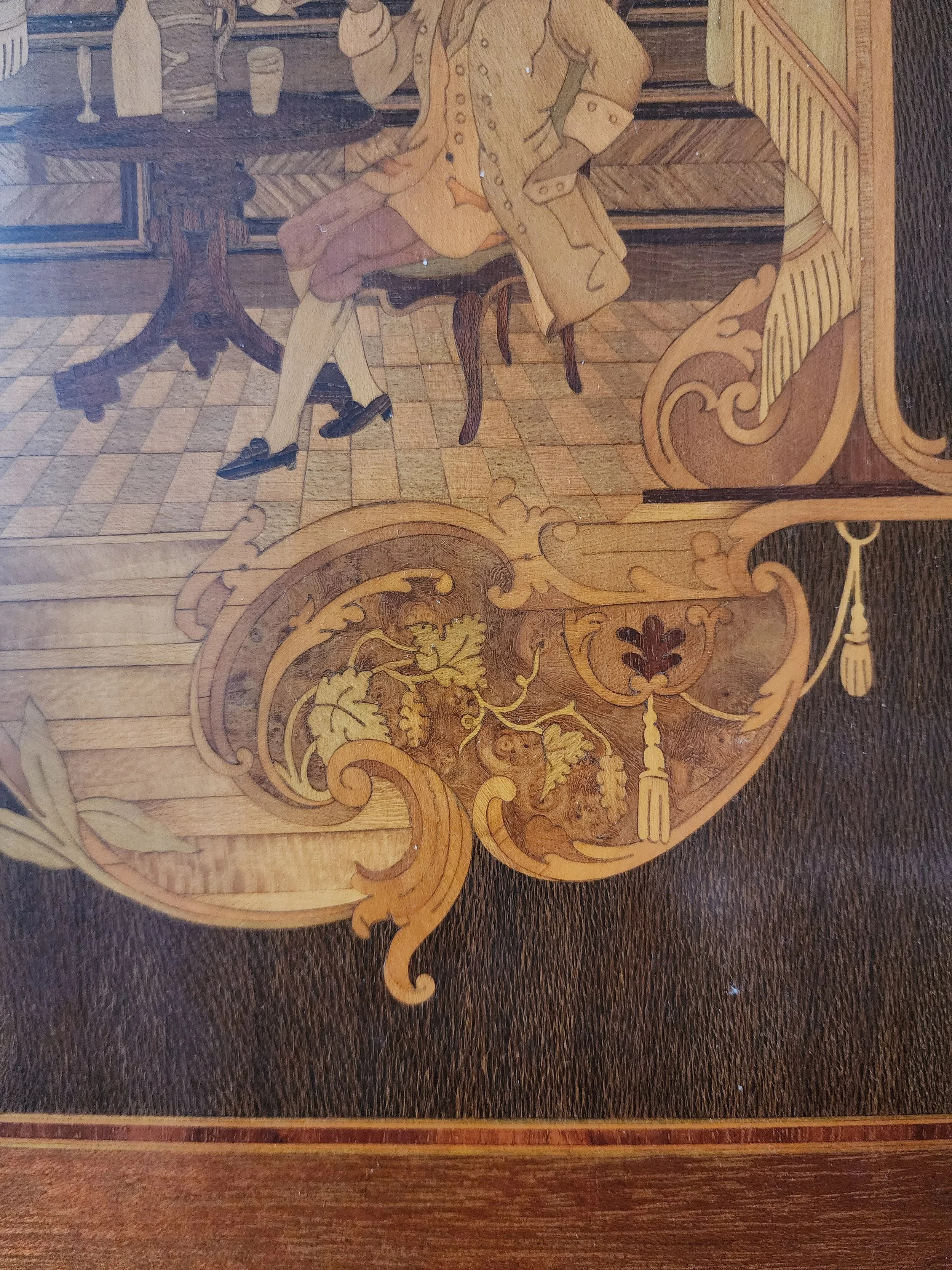 close up of inlaid wood marquetry depicting classical figures