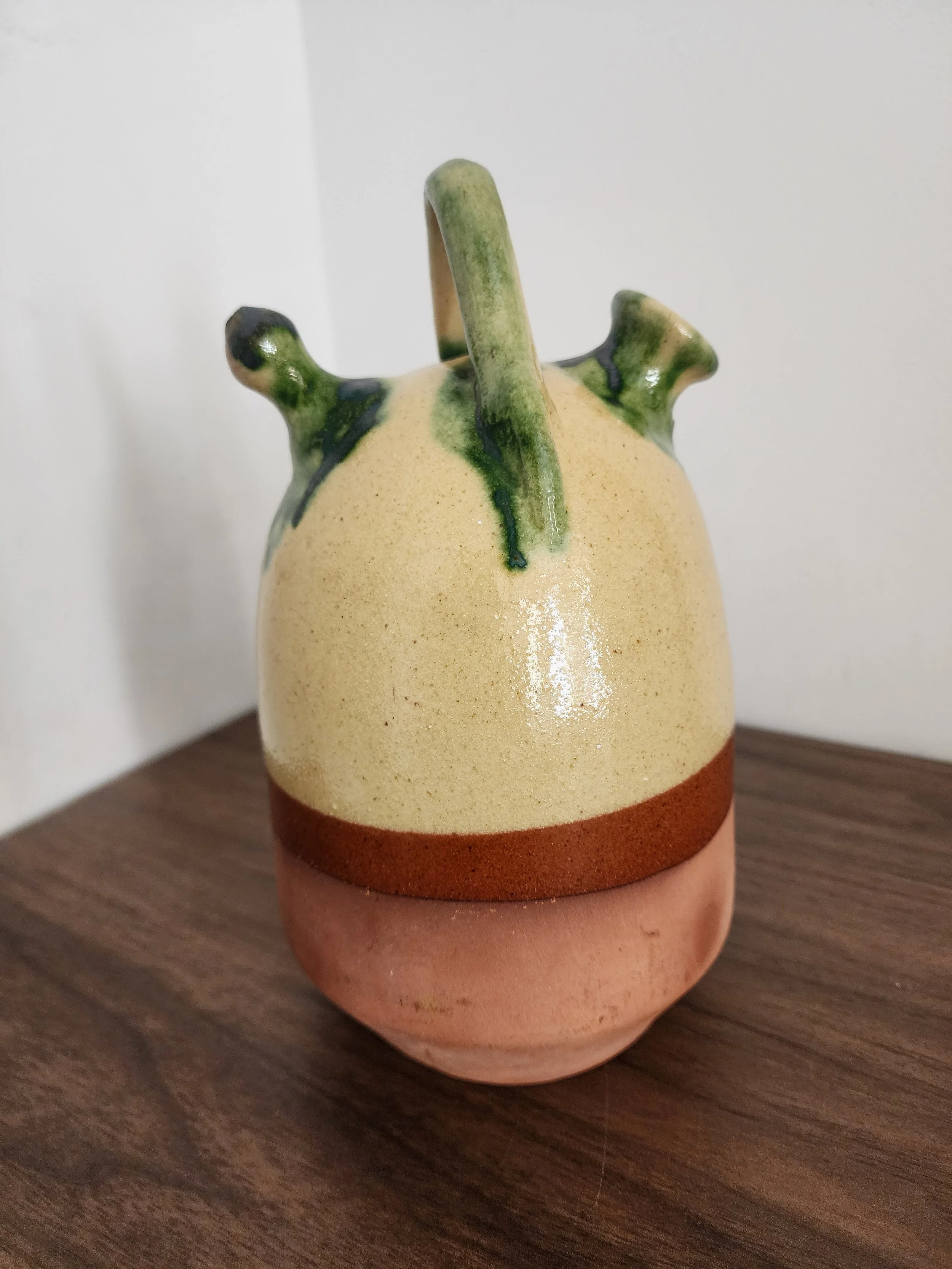 Side angle showing dual spouts and glossy drip glaze.