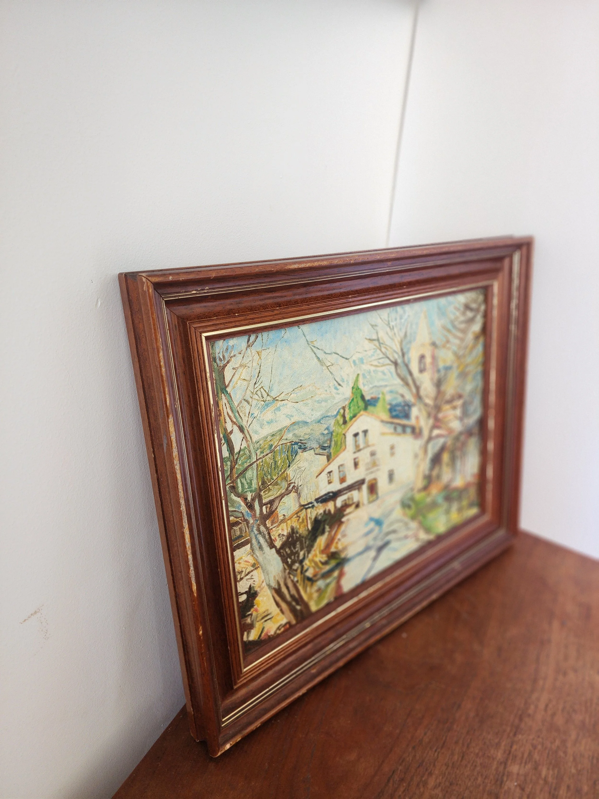 Vintage wall art in brown wooden frame on neutral linen background.
