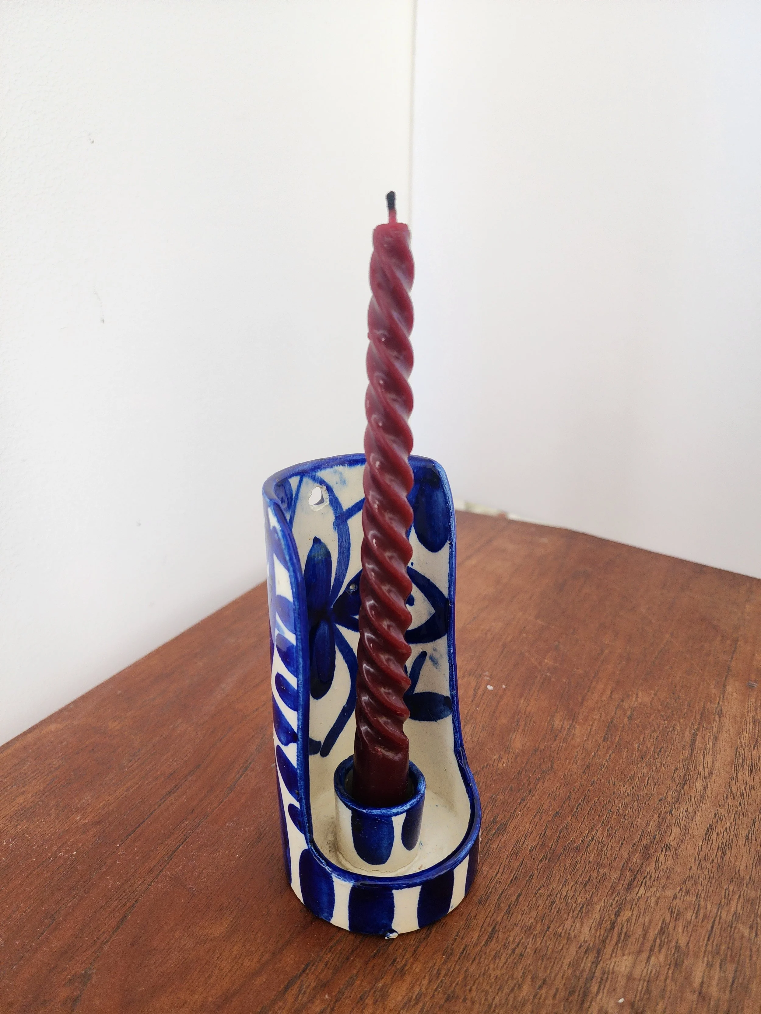 Hand-painted Talavera-style candle holder on wooden surface.