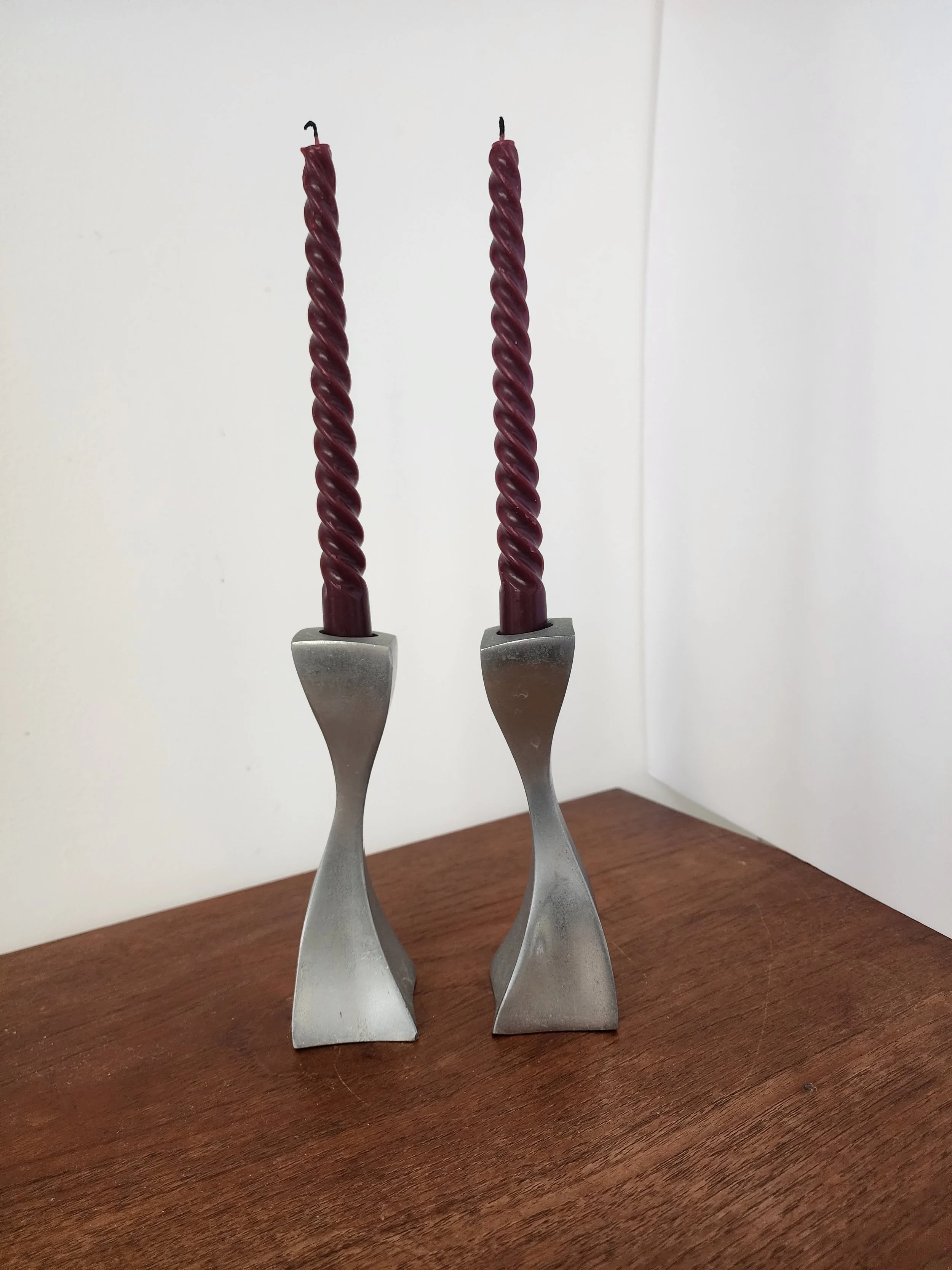 Brushed silver candle holders on wooden surface.