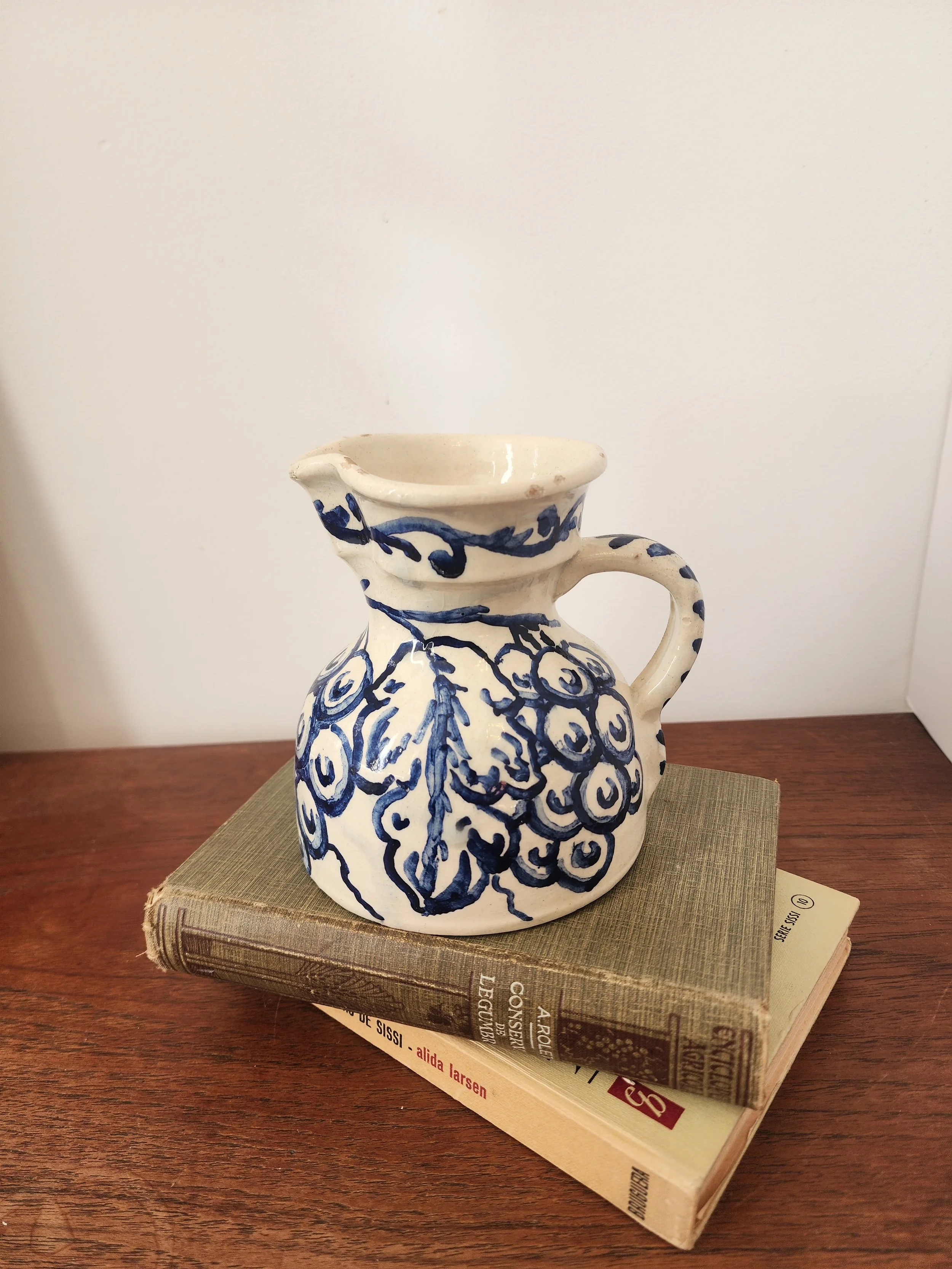 “Vintage ceramic vase-style jug with handle and blue decorative pattern.”