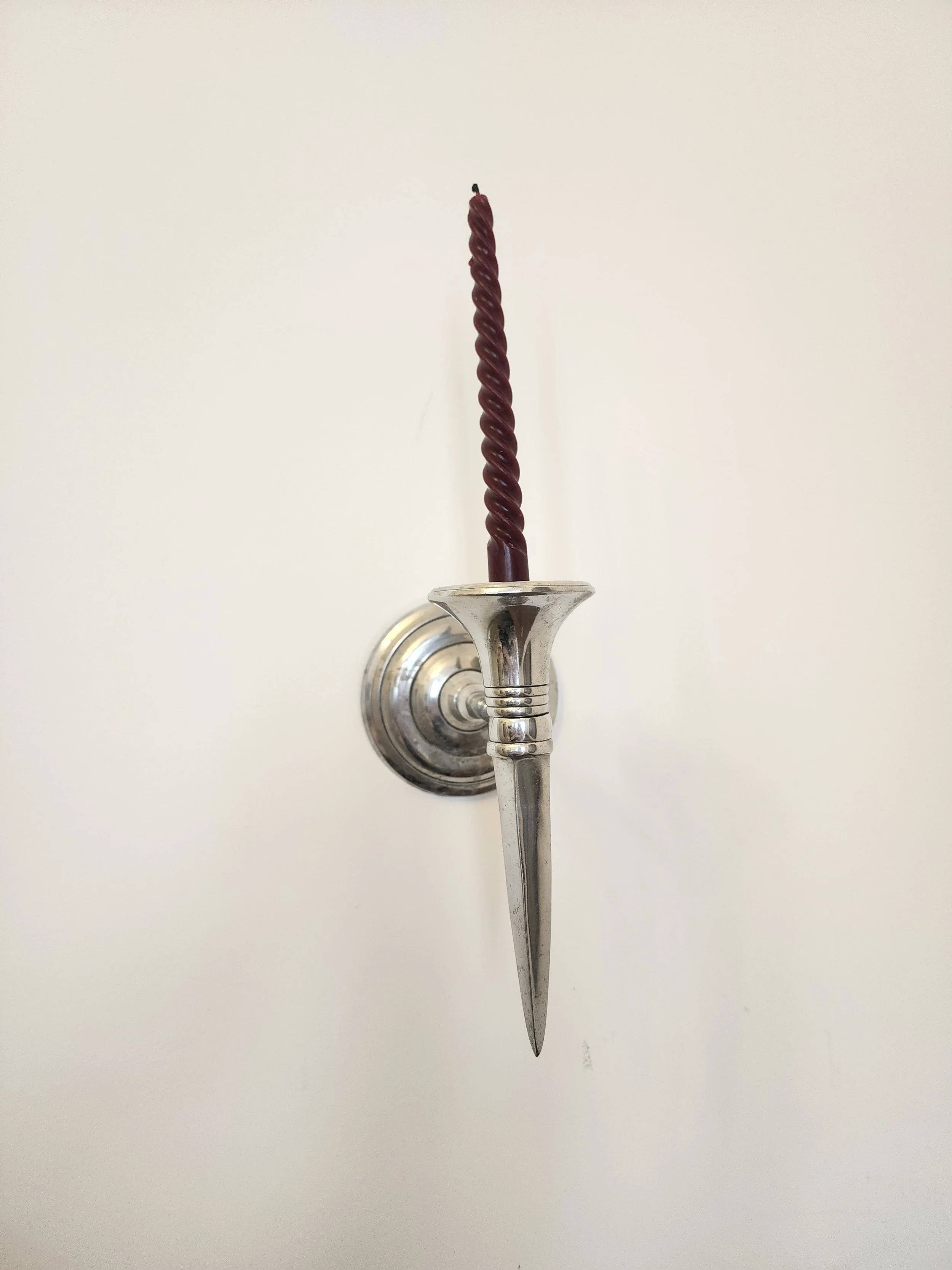 Side angle of chrome wall sconce showing projection from wall.