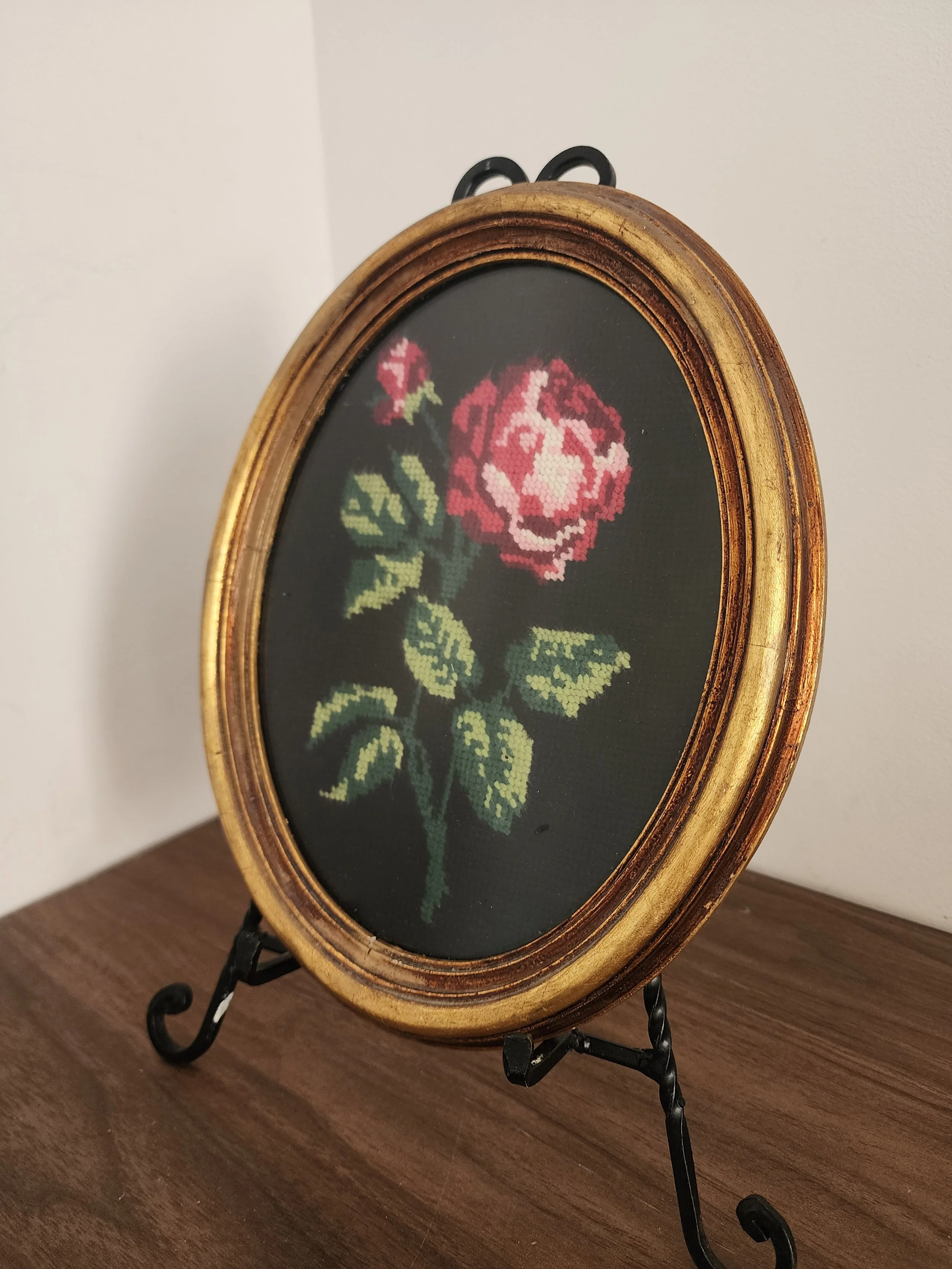 Red rose vintage embroidery displayed on table.