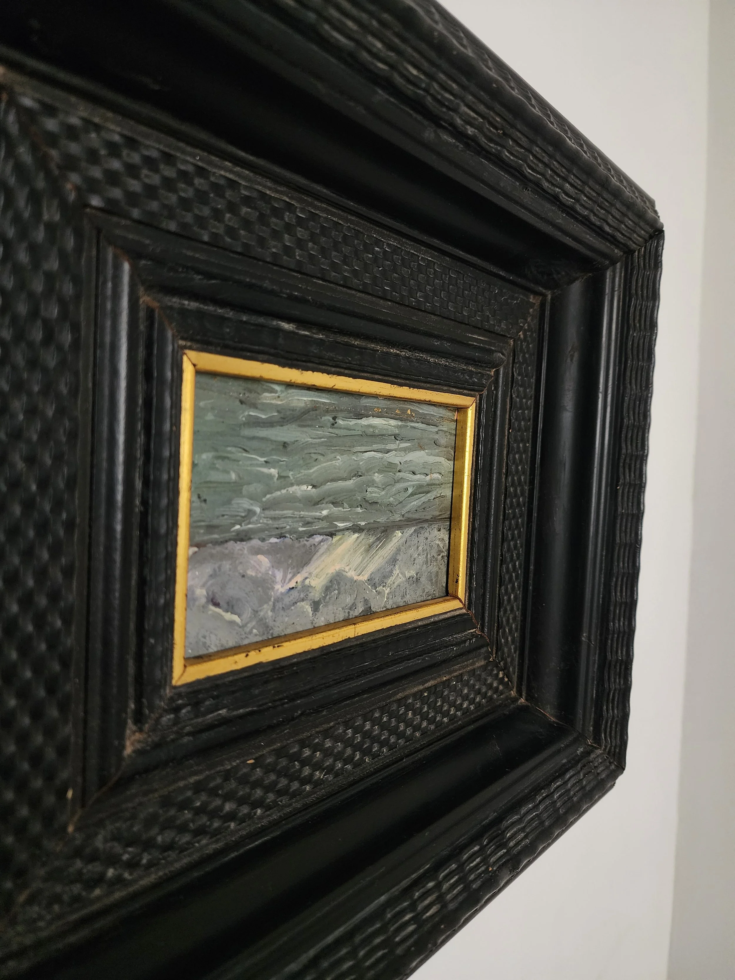 Miniature landscape art displayed in ornate black frame.