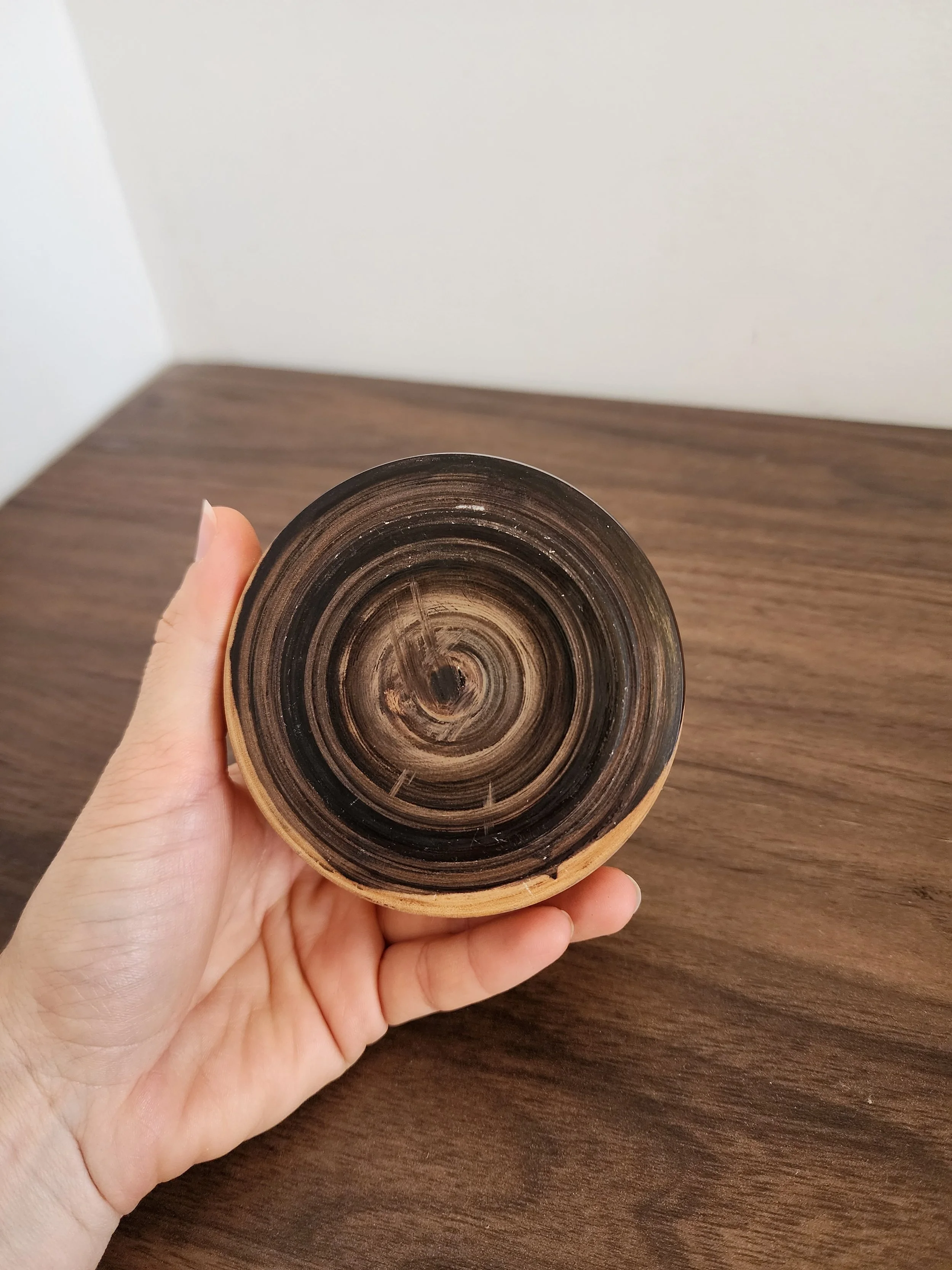 Small wooden storage jar styled on linen fabric for scale