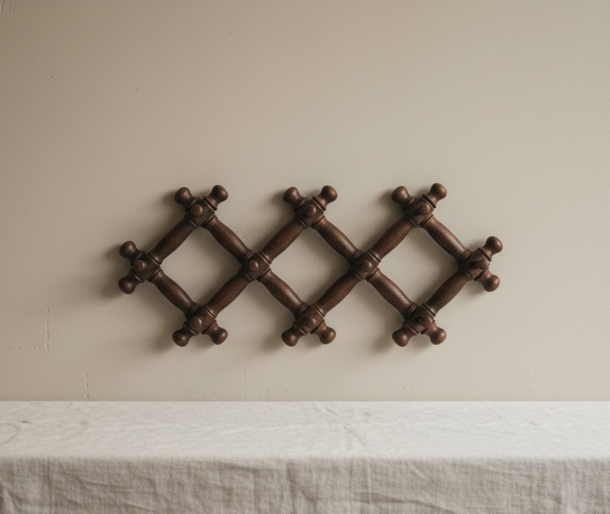 Vintage wooden accordion wall rack on neutral wall.