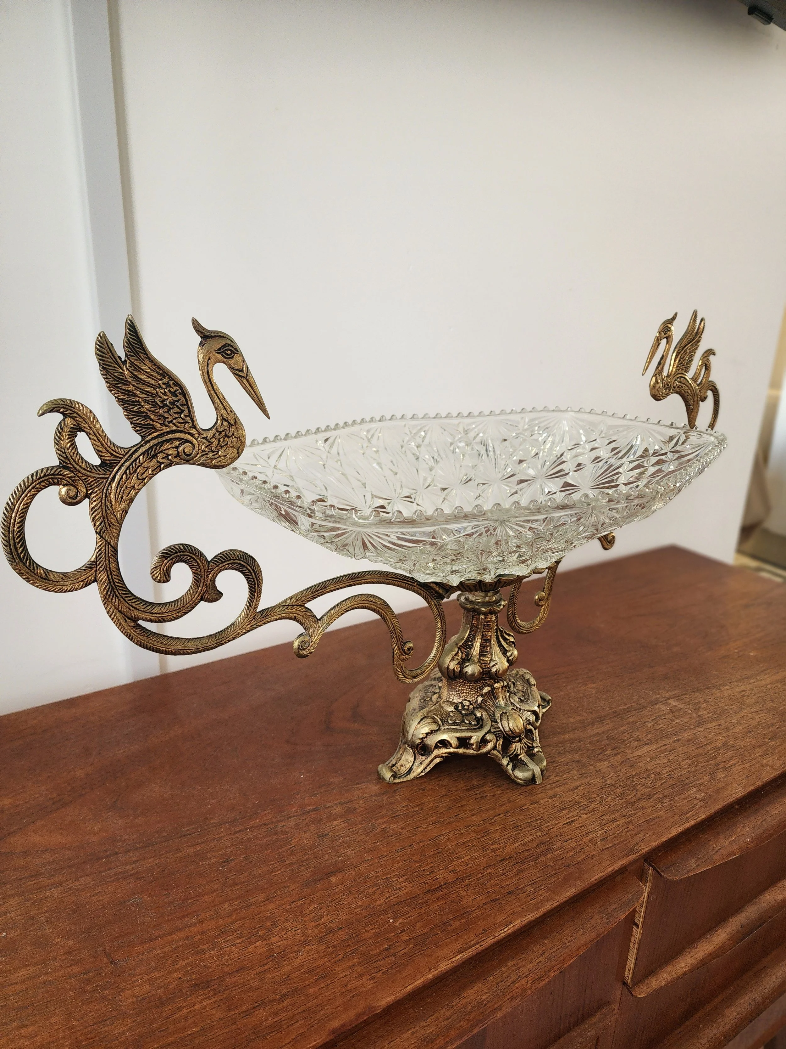 “Large vintage centerpiece featuring brass scrollwork and twin swan handles.”