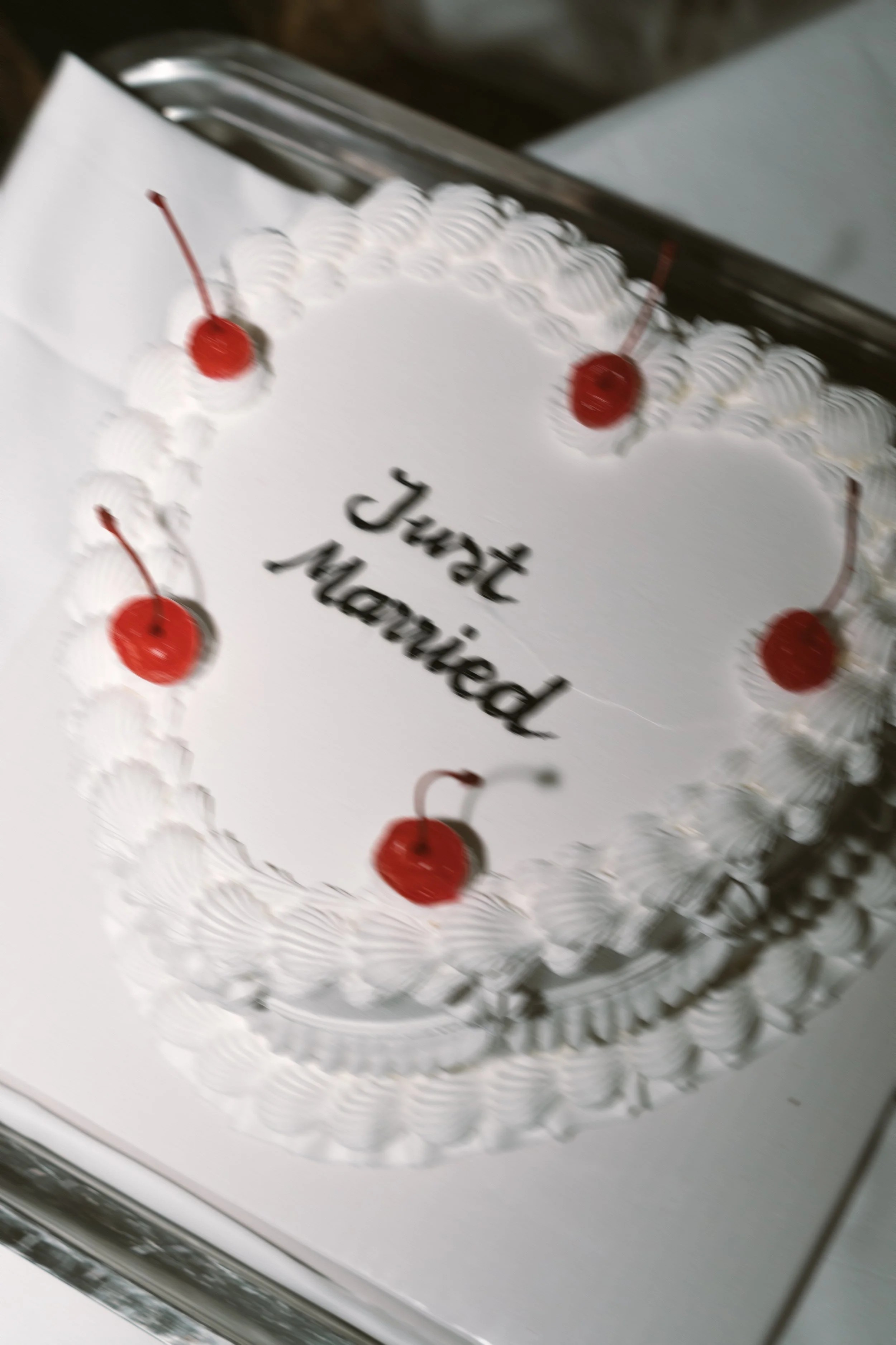 Gâteau d'anniversaire blanc avec des cerises en décoration et un message écrit : "Joyeux anniversaire".