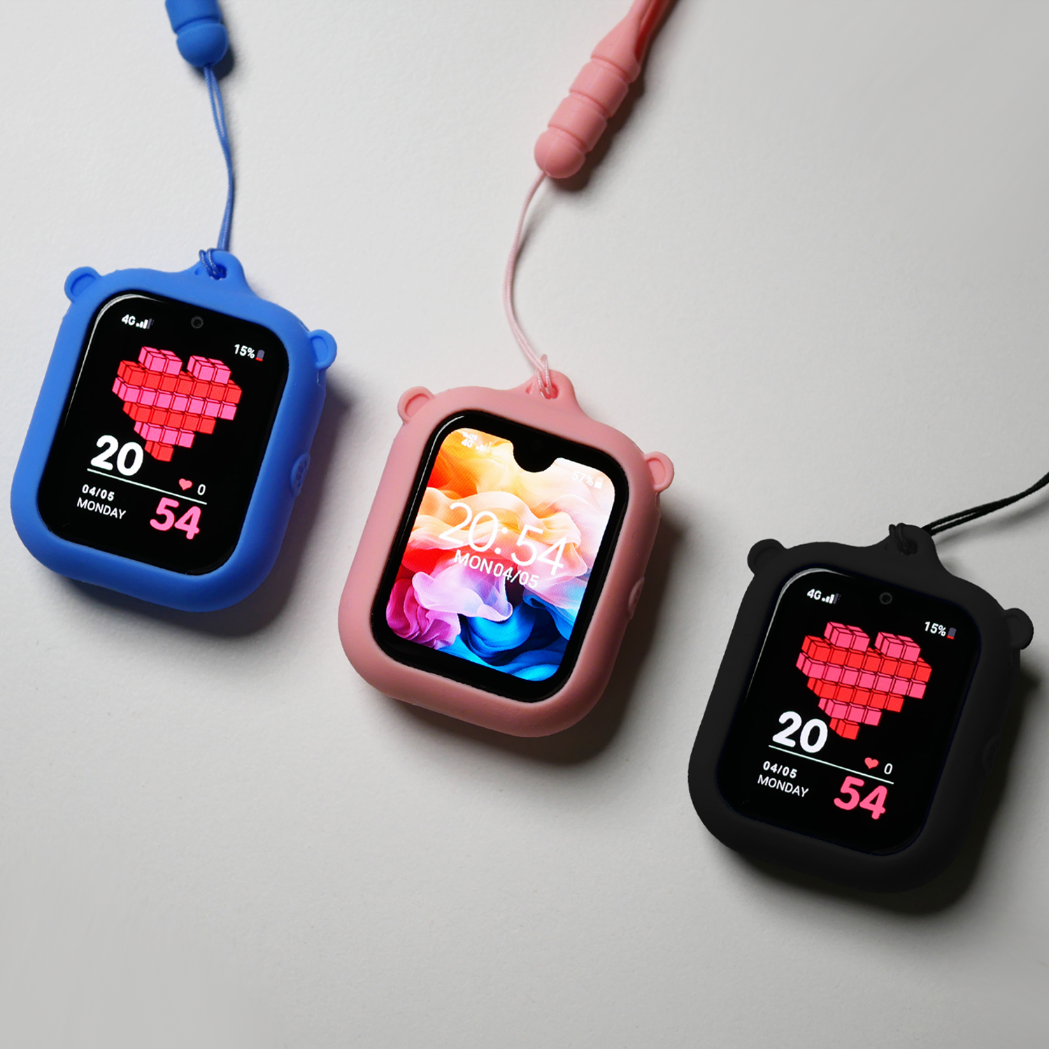 Three small digital watches with colorful bear-shaped cases, two with bear ears on the top corners. The watches display various screens, with one showing a pixel art heart and others showing time and date, all attached to lanyards.