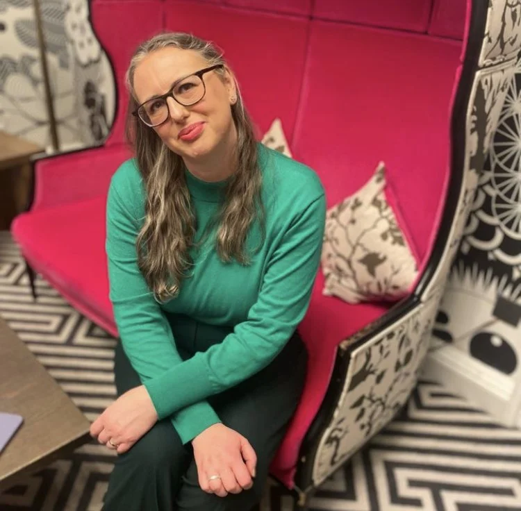 Photograph of Anna Campbell of Jewellery School Scotland sitting on a brightly coloured sofa