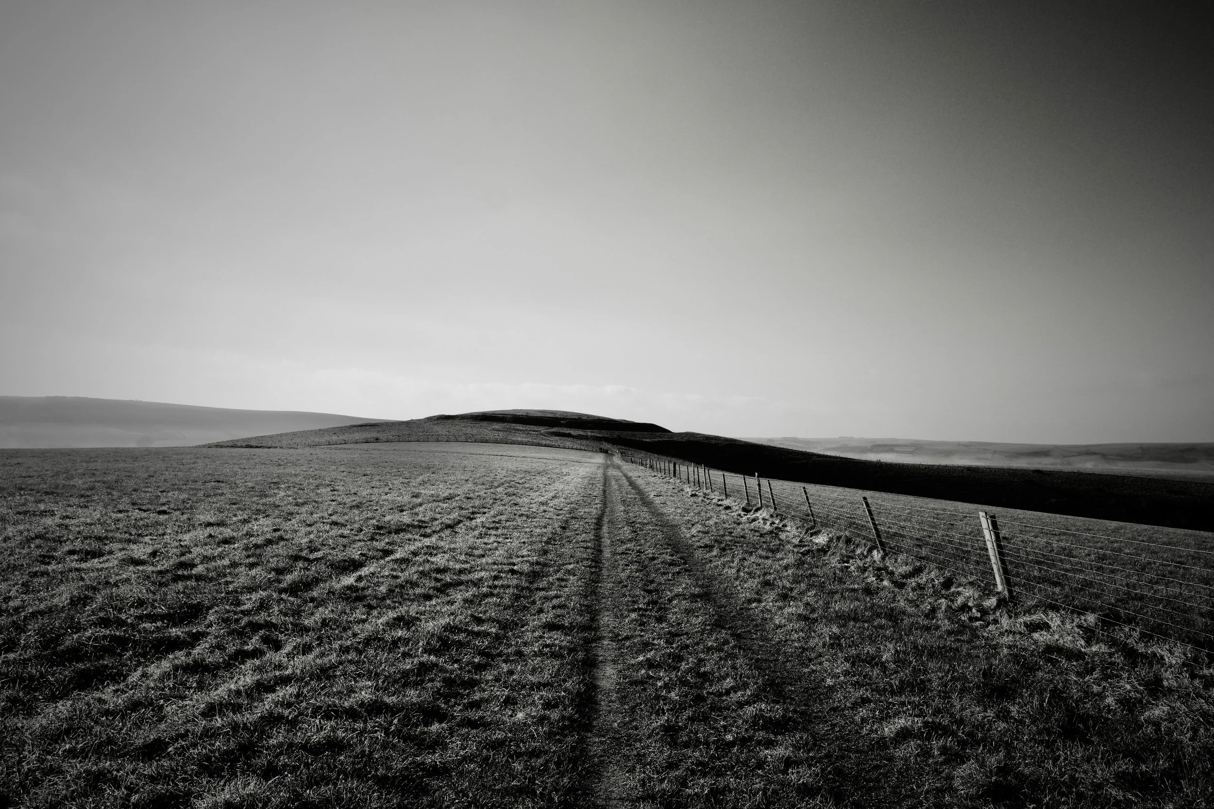 A high contrast black and white photograph of the South Downs at Mount Caburn near Lewes by John Worth, Artist