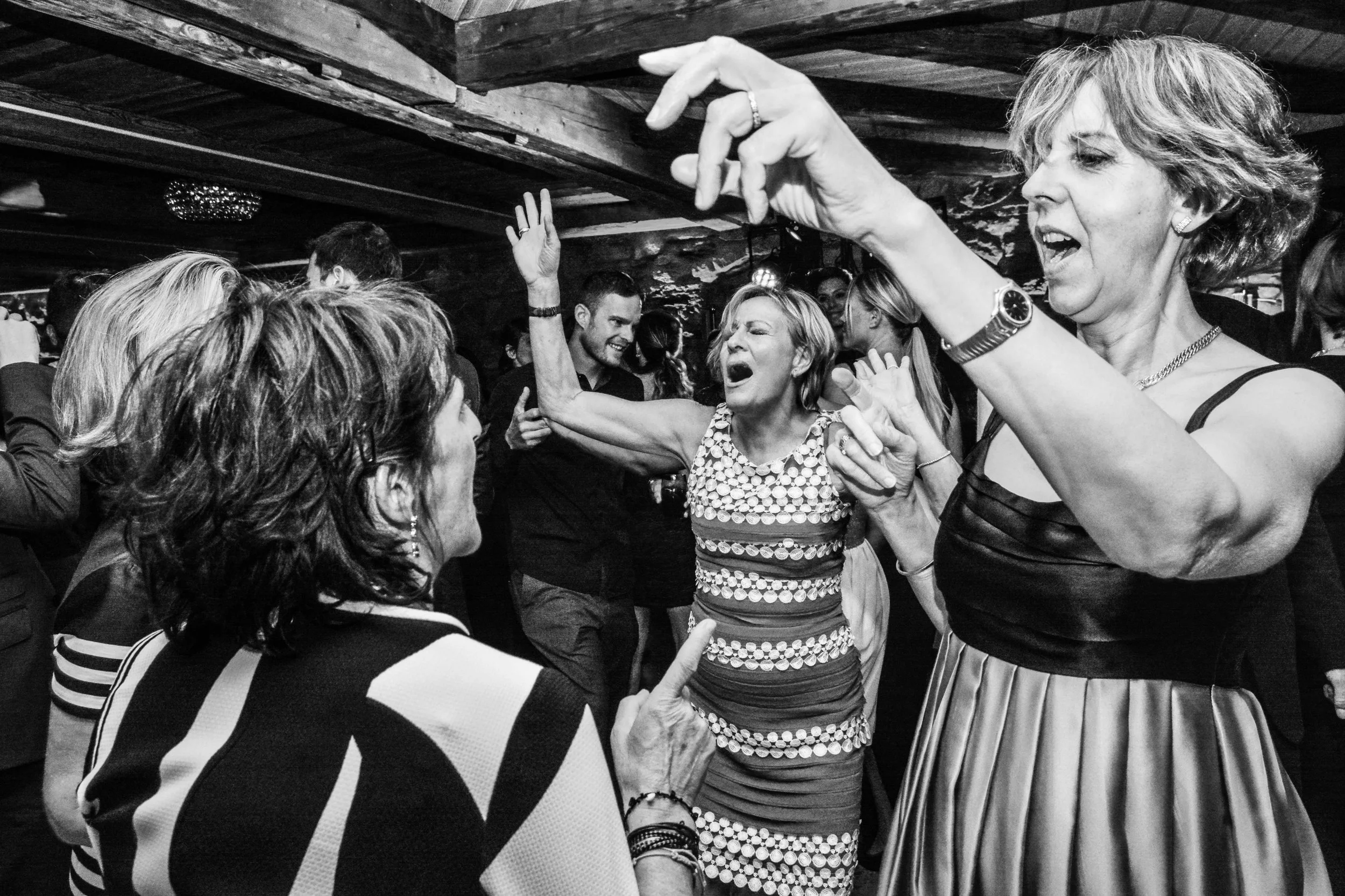 Groupe de personnes dansant et s'amusant lors d'une fête, en noir et blanc.