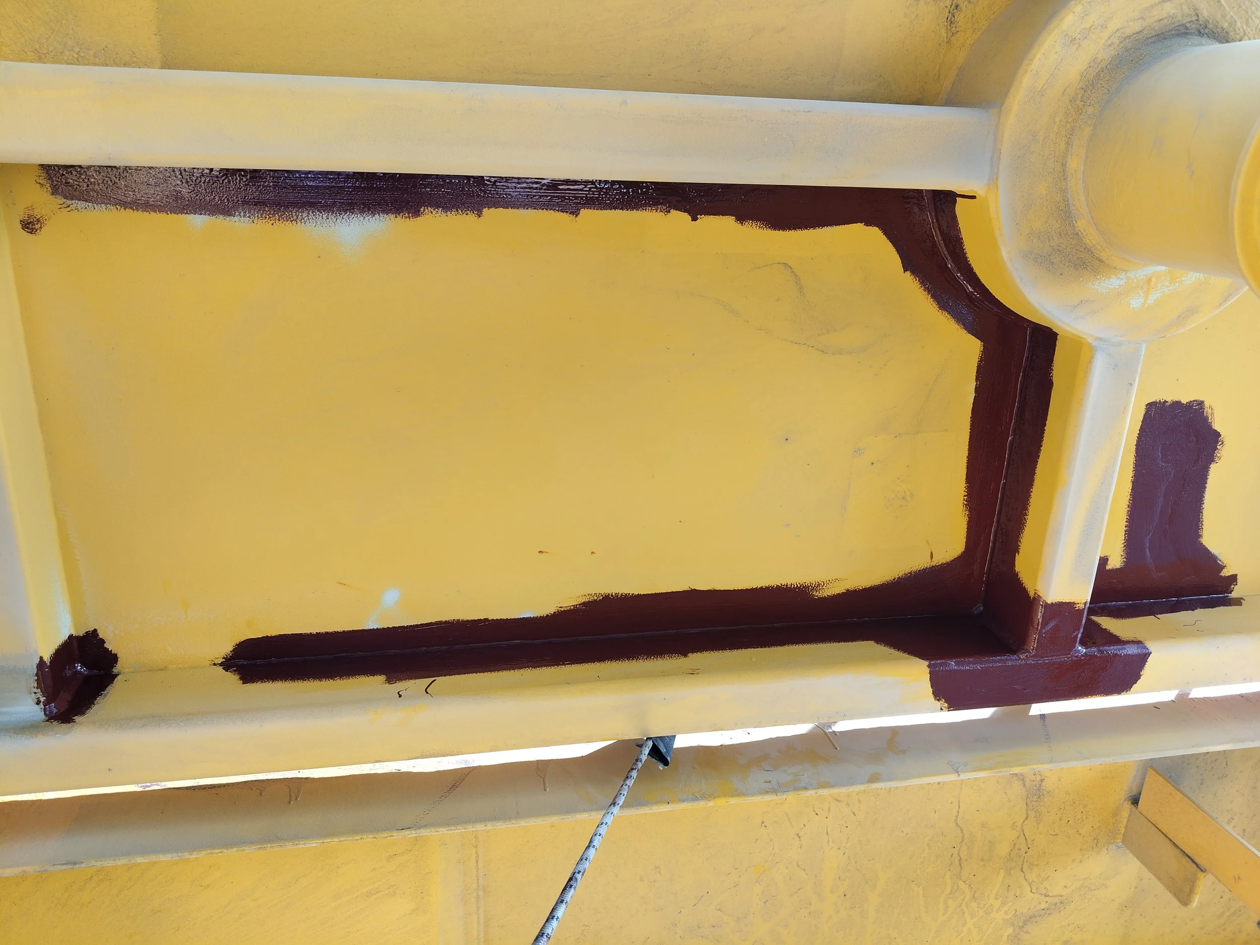 Yellow surface with a rectangular outline painted in dark red or brown.