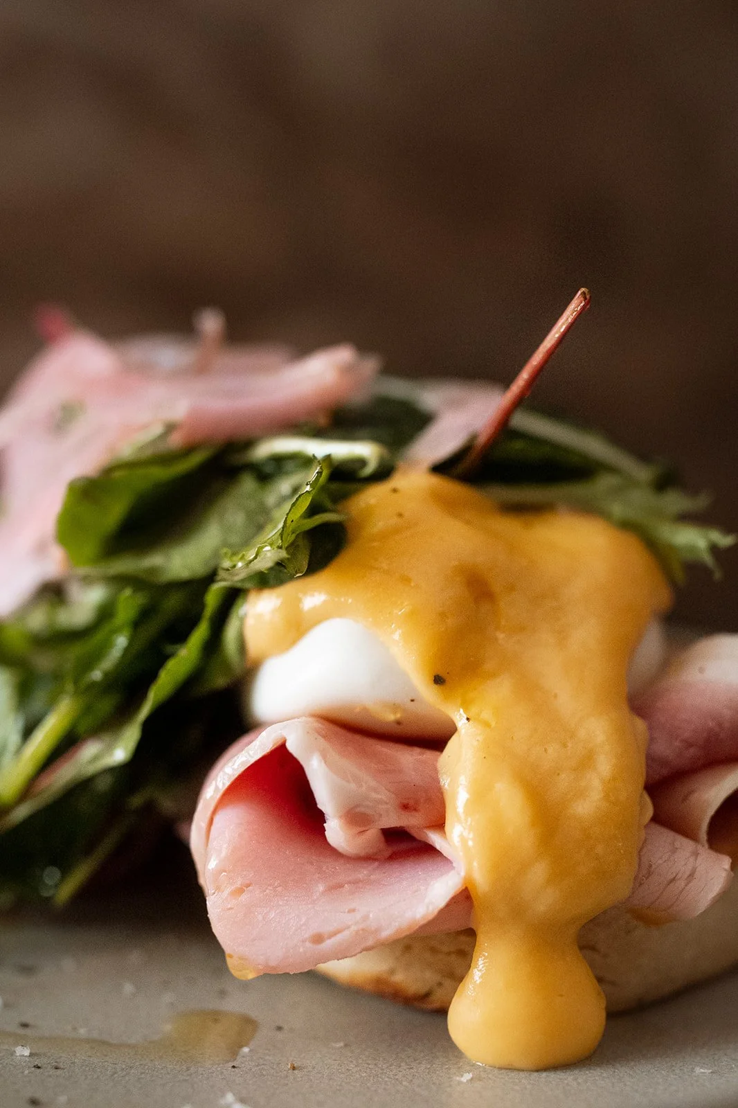 Close-up of a sandwich with ham, greens, and melted cheese