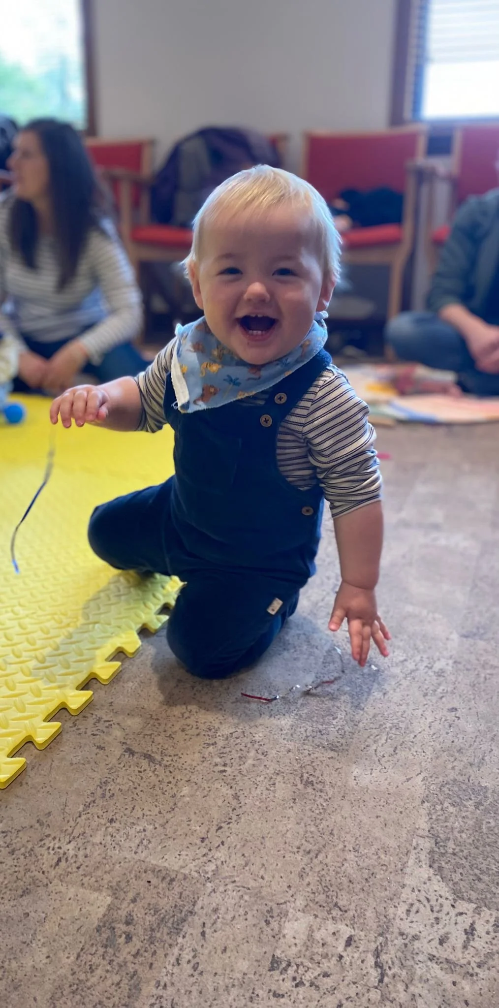 baby boy in blue dungarees laughing