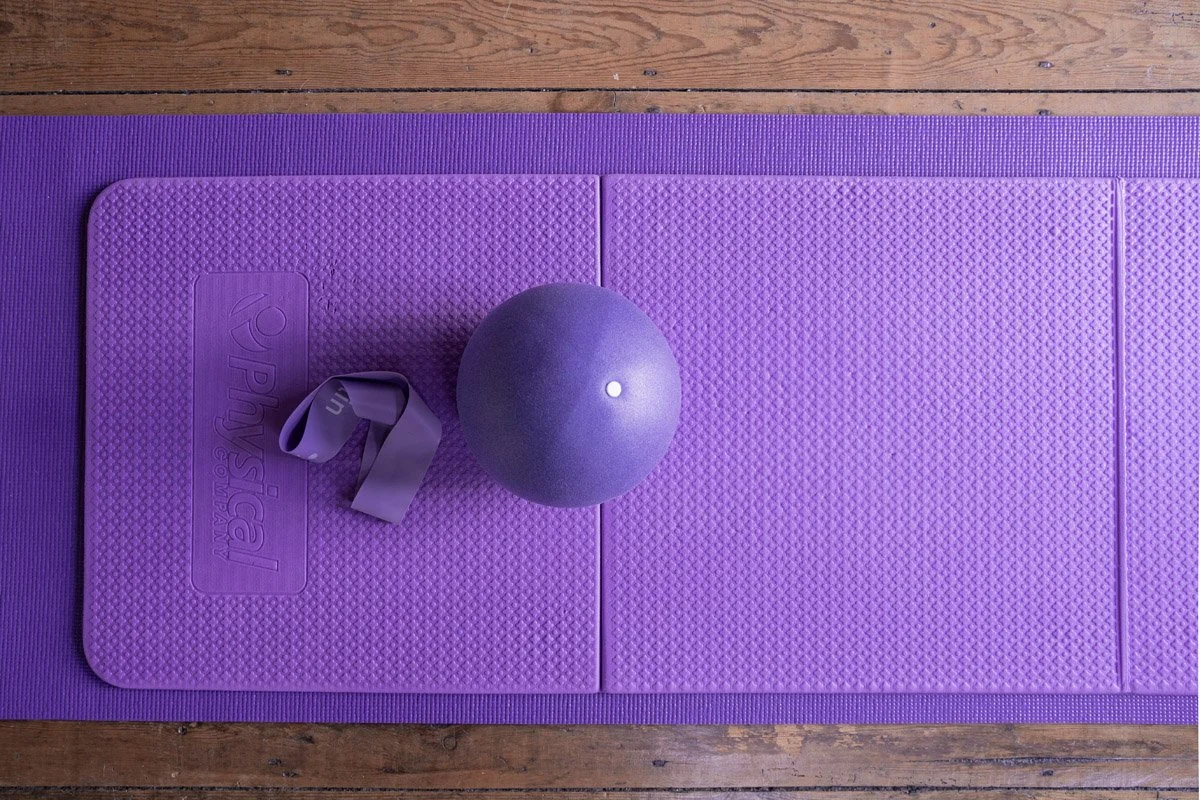 Pilates ball and band on purple mat