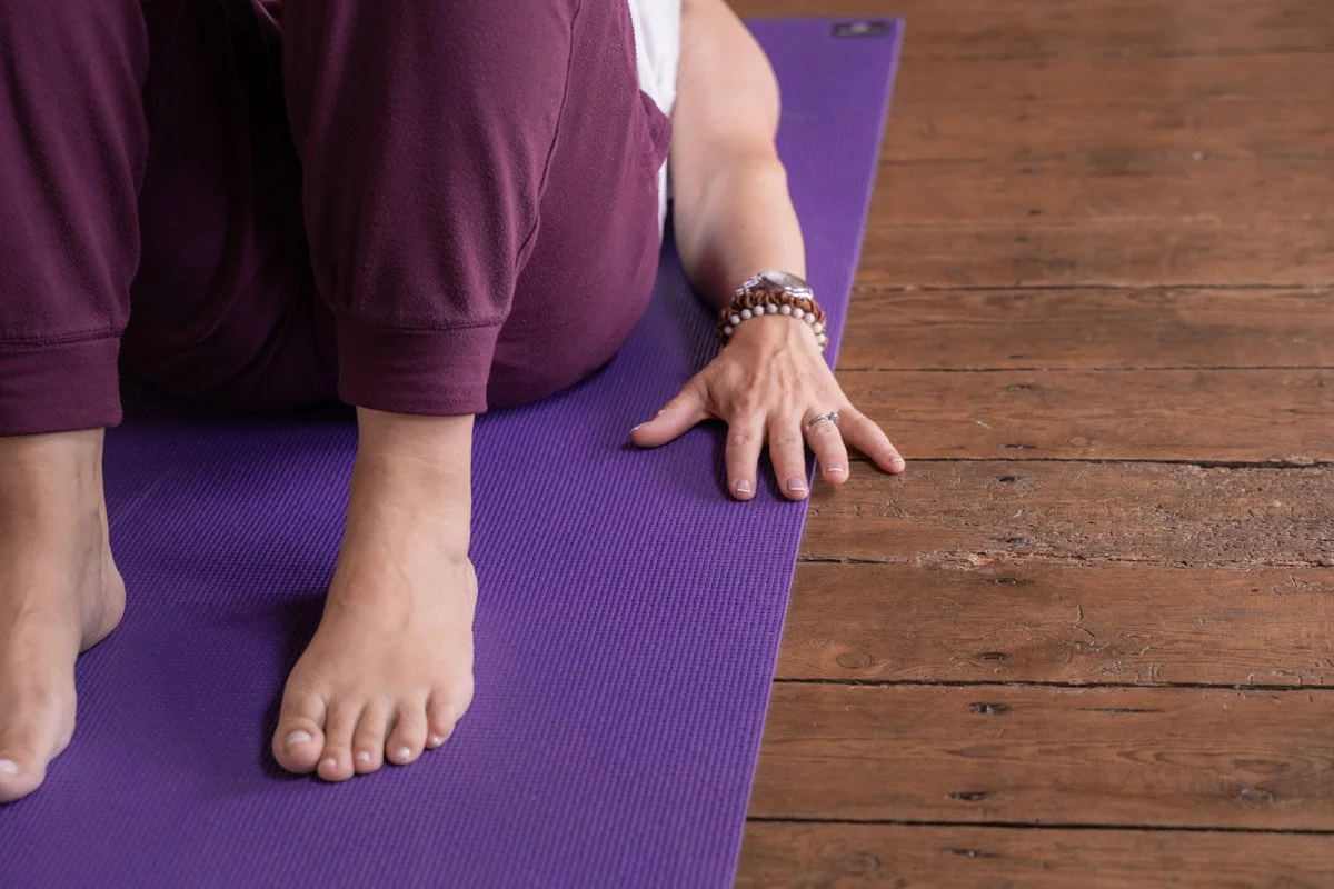 Paula Edmonds lying on purple Pilates mat