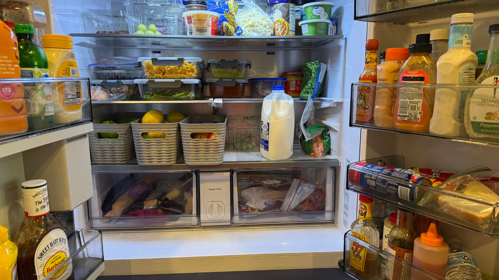 Open refrigerator showing high-protein foods and weekly meal prep for a family, used to support strength training