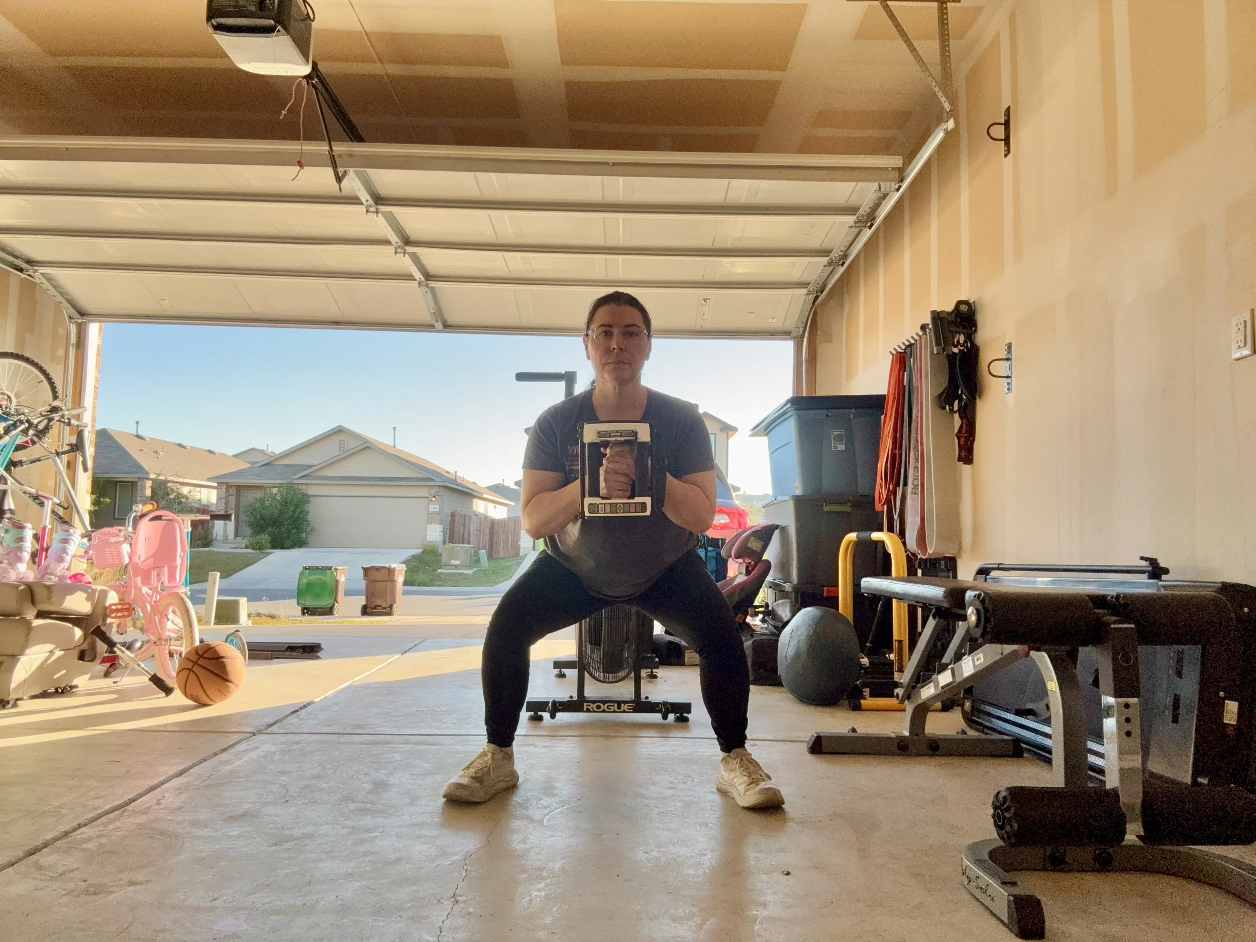 Busy mom working out in her garage gym, building muscle at 48 and in perimenopause while kids are home.