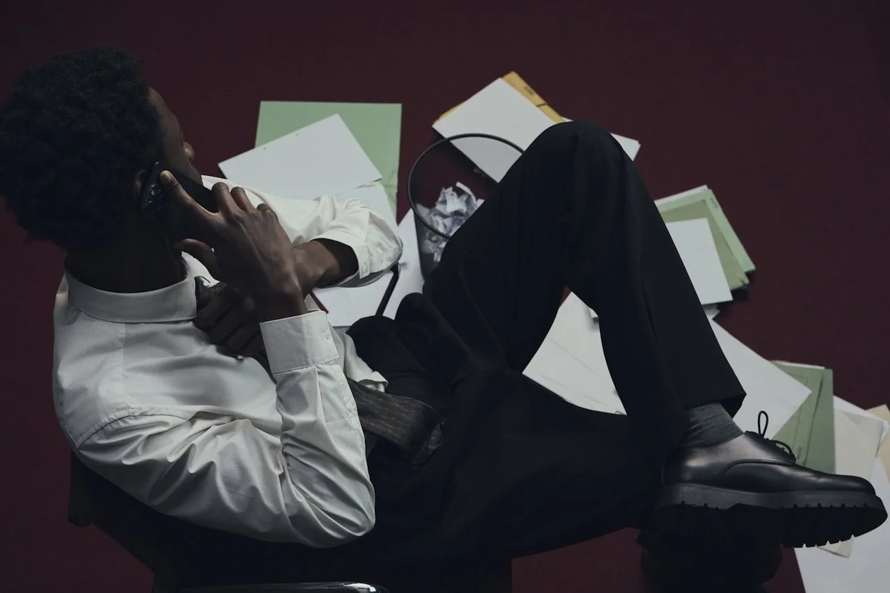 Business owner reviewing documents on the floor while on a phone call