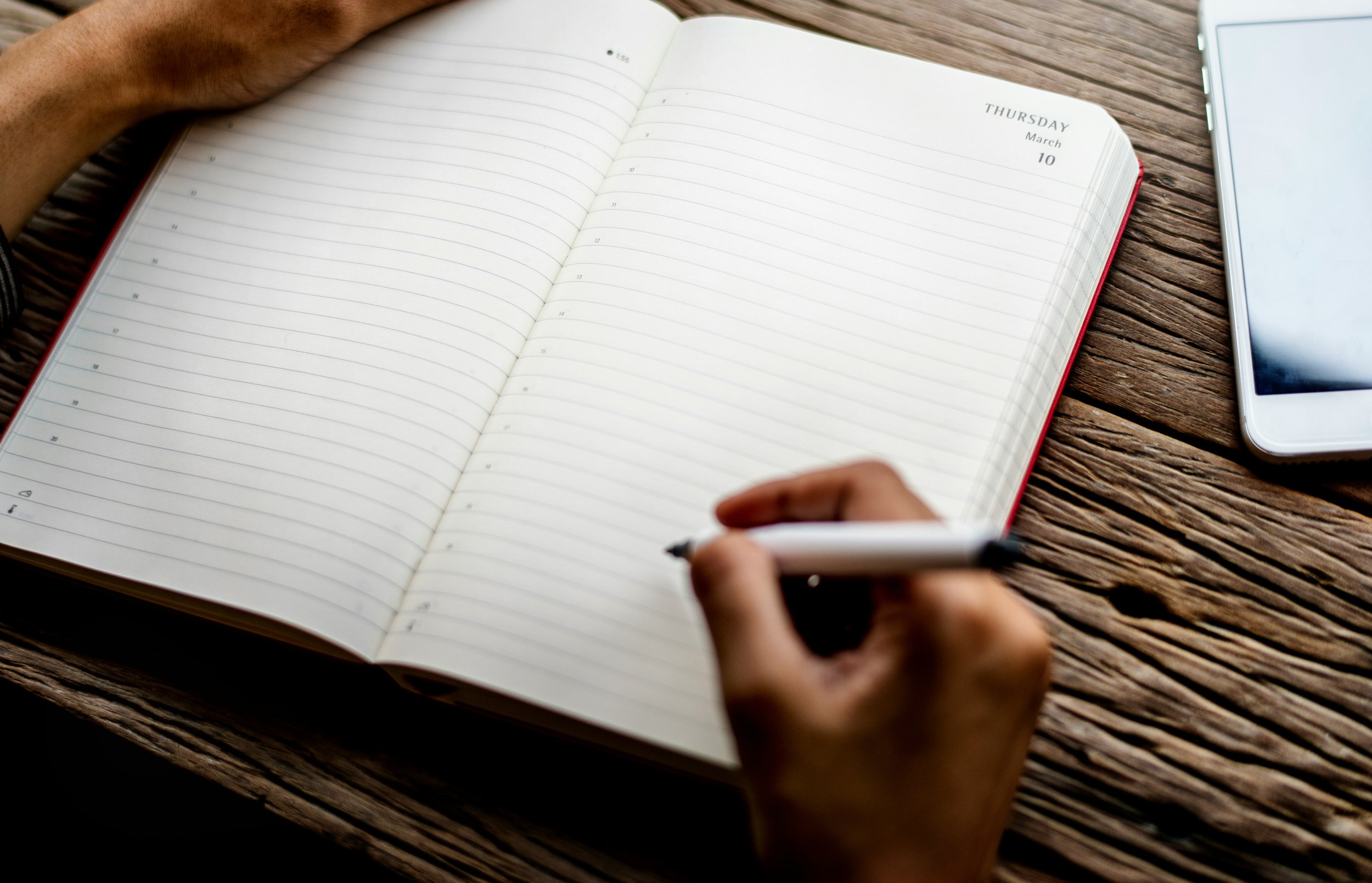 Person preparing to write brand strategy notes in a notebook