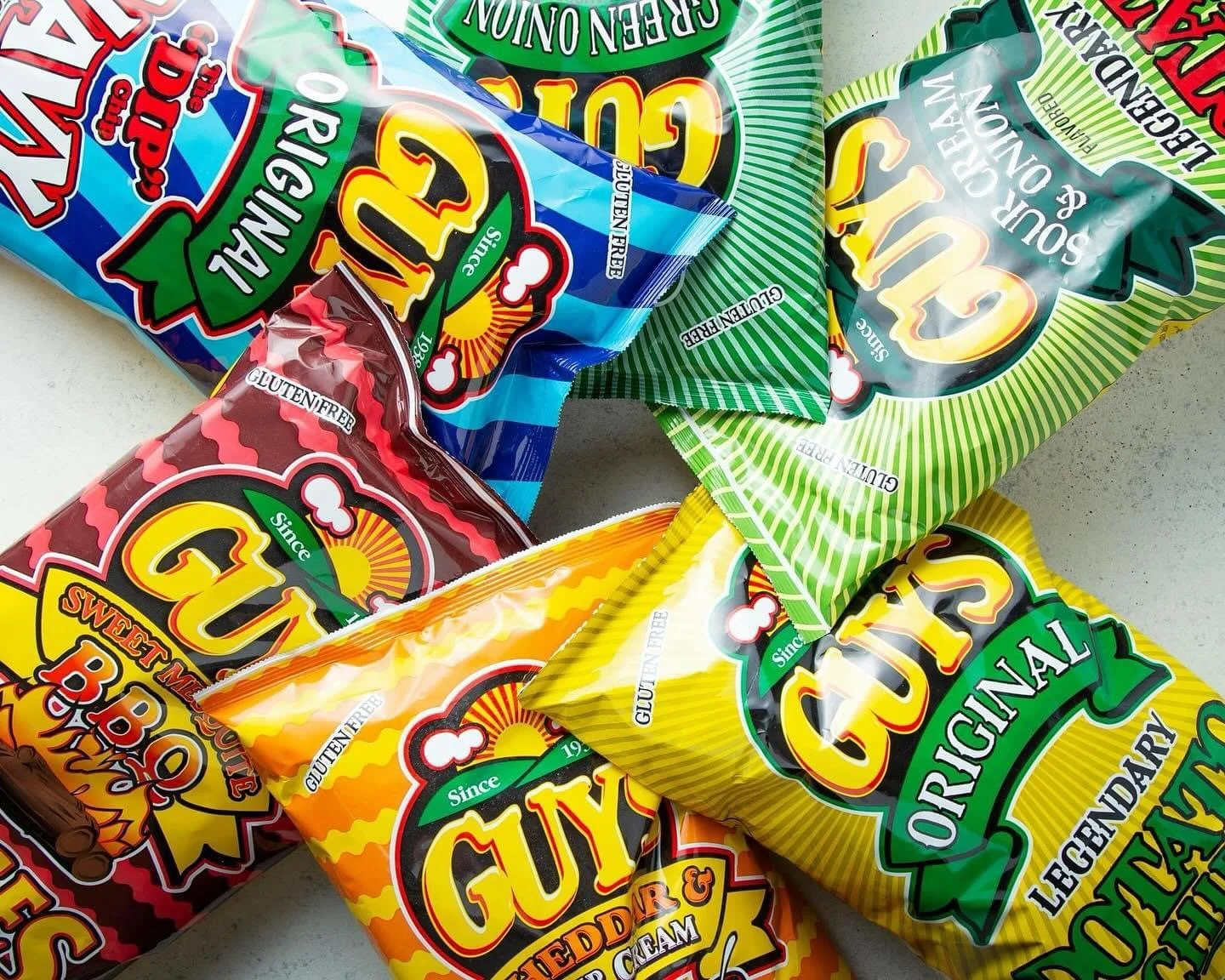 Elm Creek Beef Various flavors of Guylian brand candy bags with colorful packaging, including yellow, red, green, blue, and orange, on a flat surface.