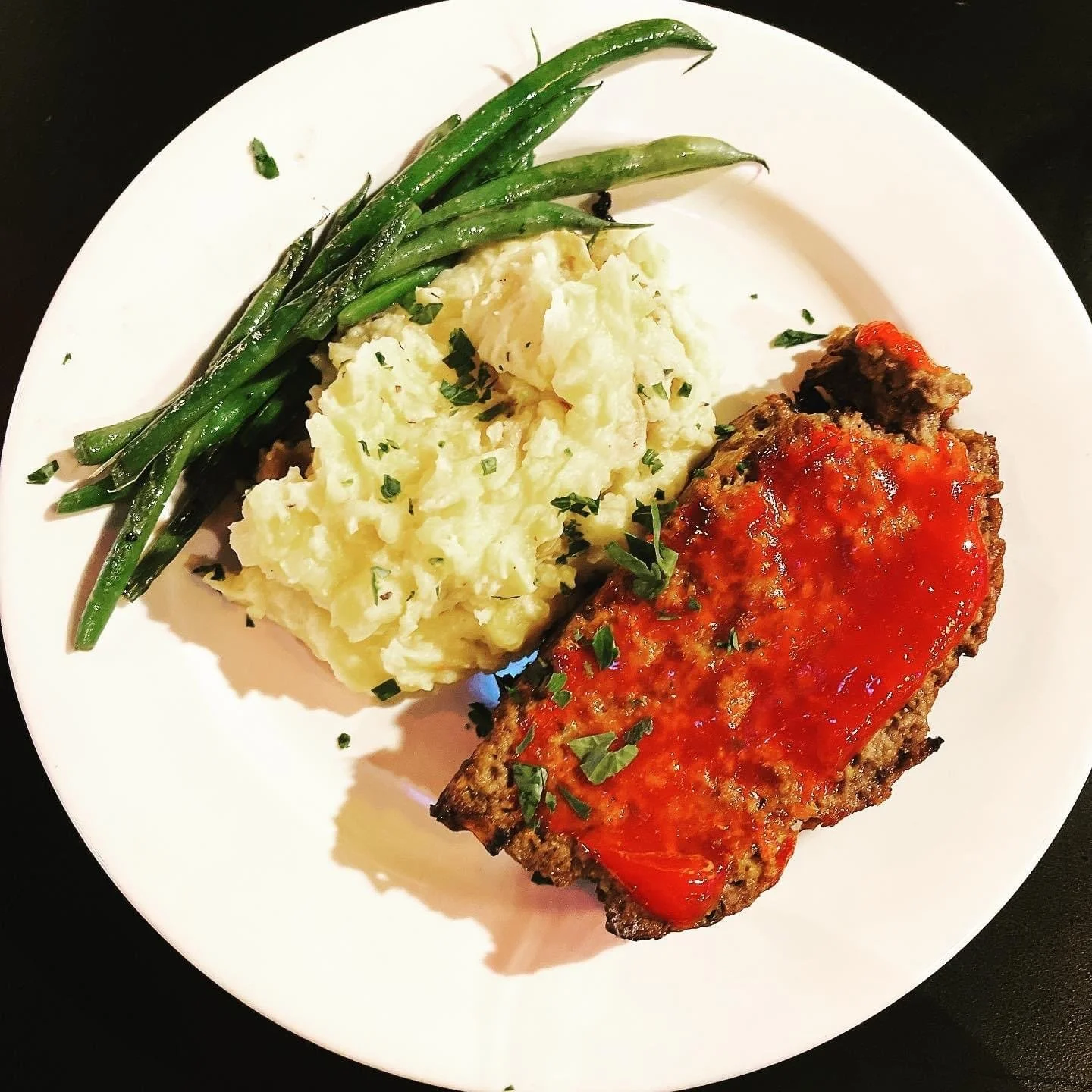 Elm Creek Beef Plate with green beans, mashed potatoes, and a beef patty topped with tomato sauce.
