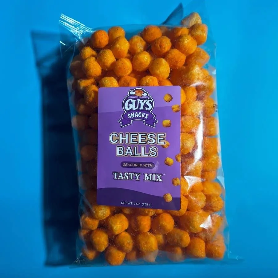 Elm Creek Beef A clear plastic bag of orange cheese balls snack with a purple label that reads 'GUYS Snacks Cheese Balls Seasoned with Tasty Mix,' against a blue background.