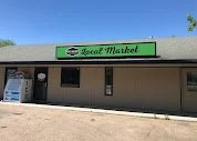 Exterior of a local market store with a green and white sign reading 'Local Market' Elm Creek Beef