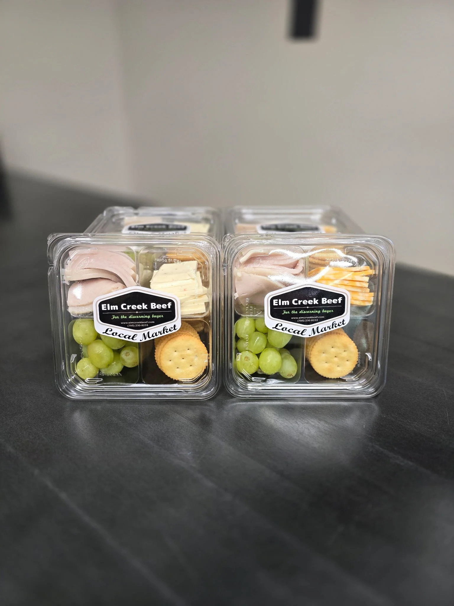Elm Creek Beef Clear plastic containers with deli meat, cheese, grapes, and crackers from Elm Creek Beef at a local market