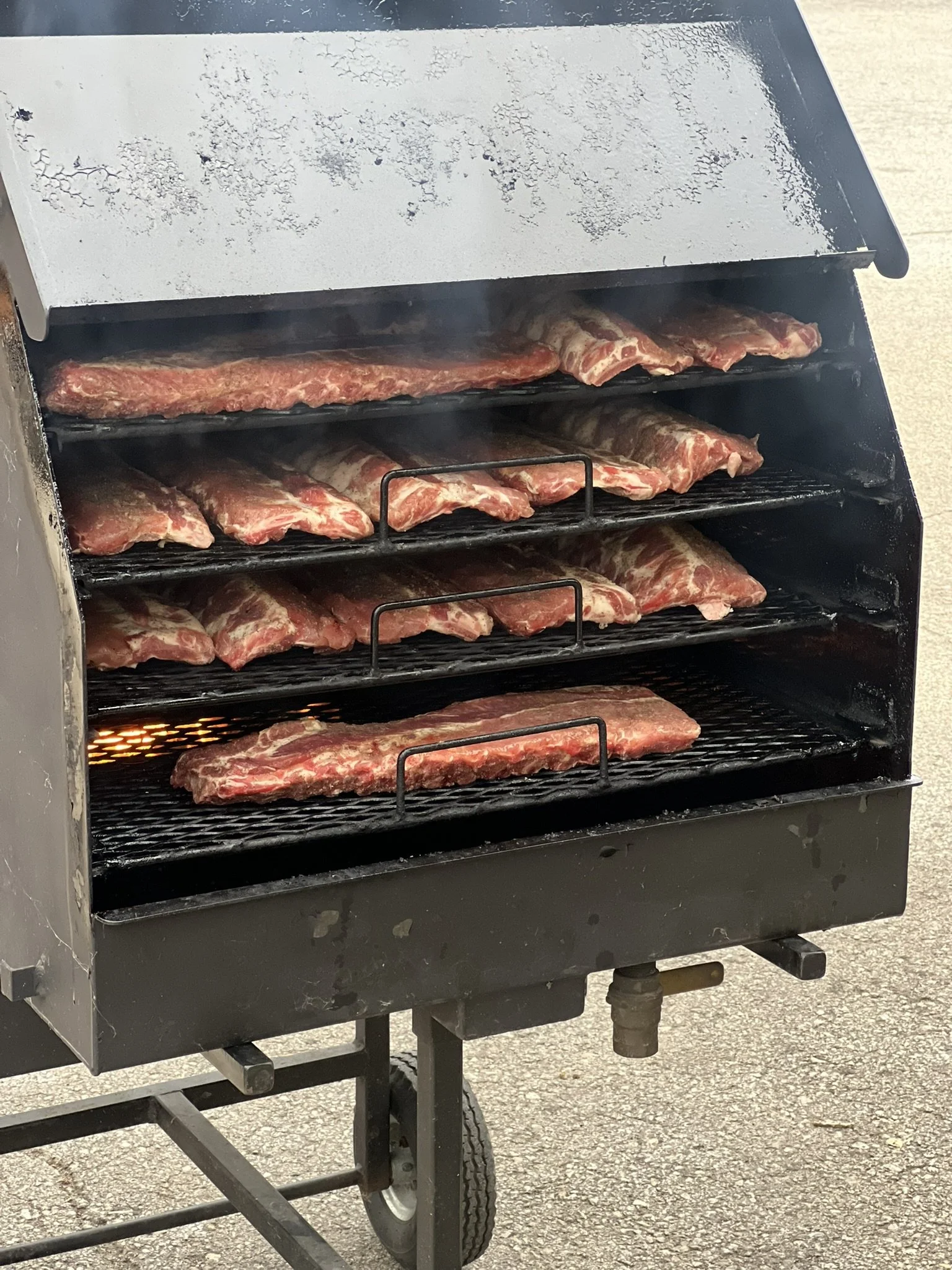 Elm Creek Beef Barbecue grill with raw meat on the racks.