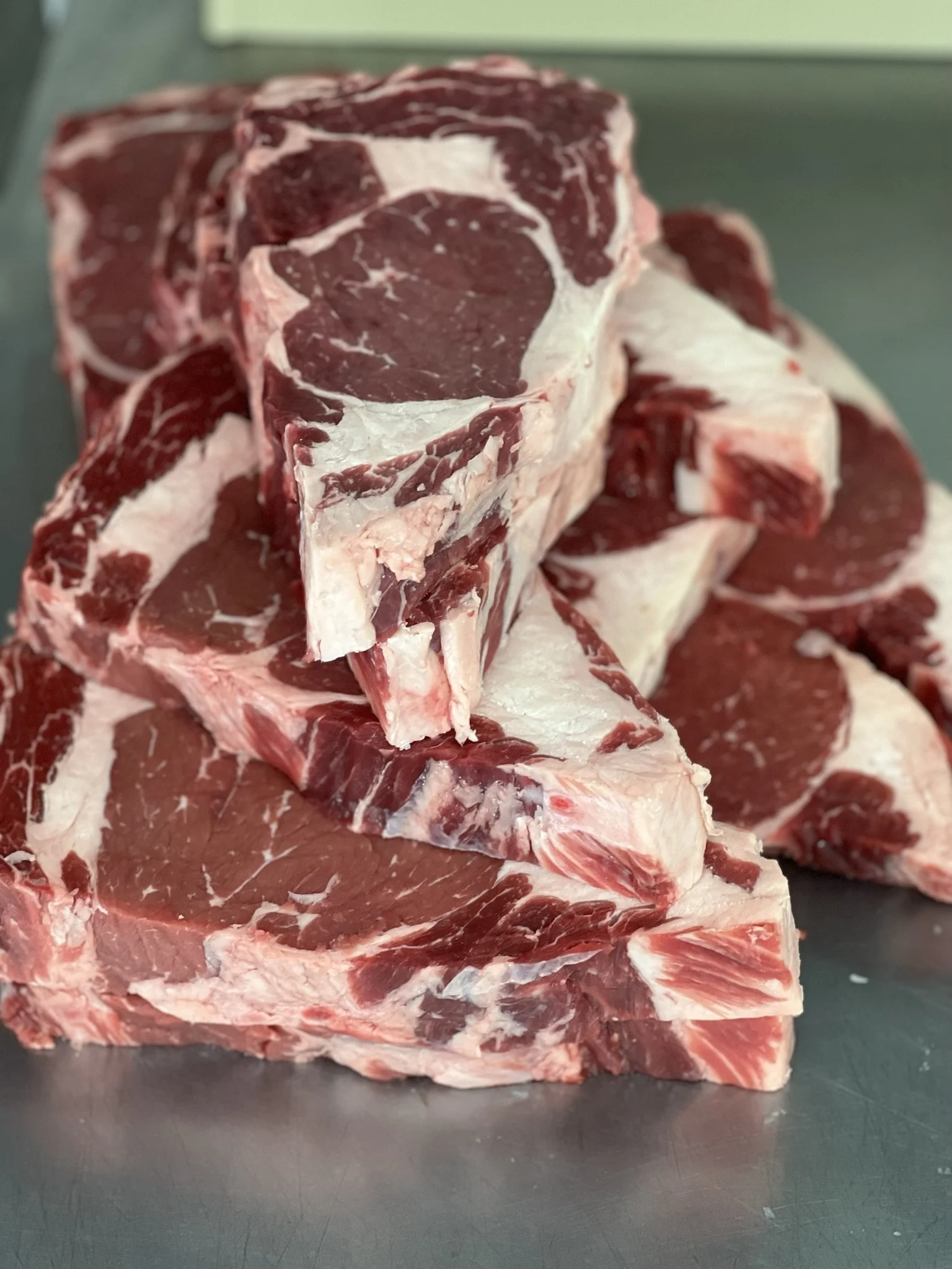 Elm Creek Beef Beef short ribs stacked on a metal surface.